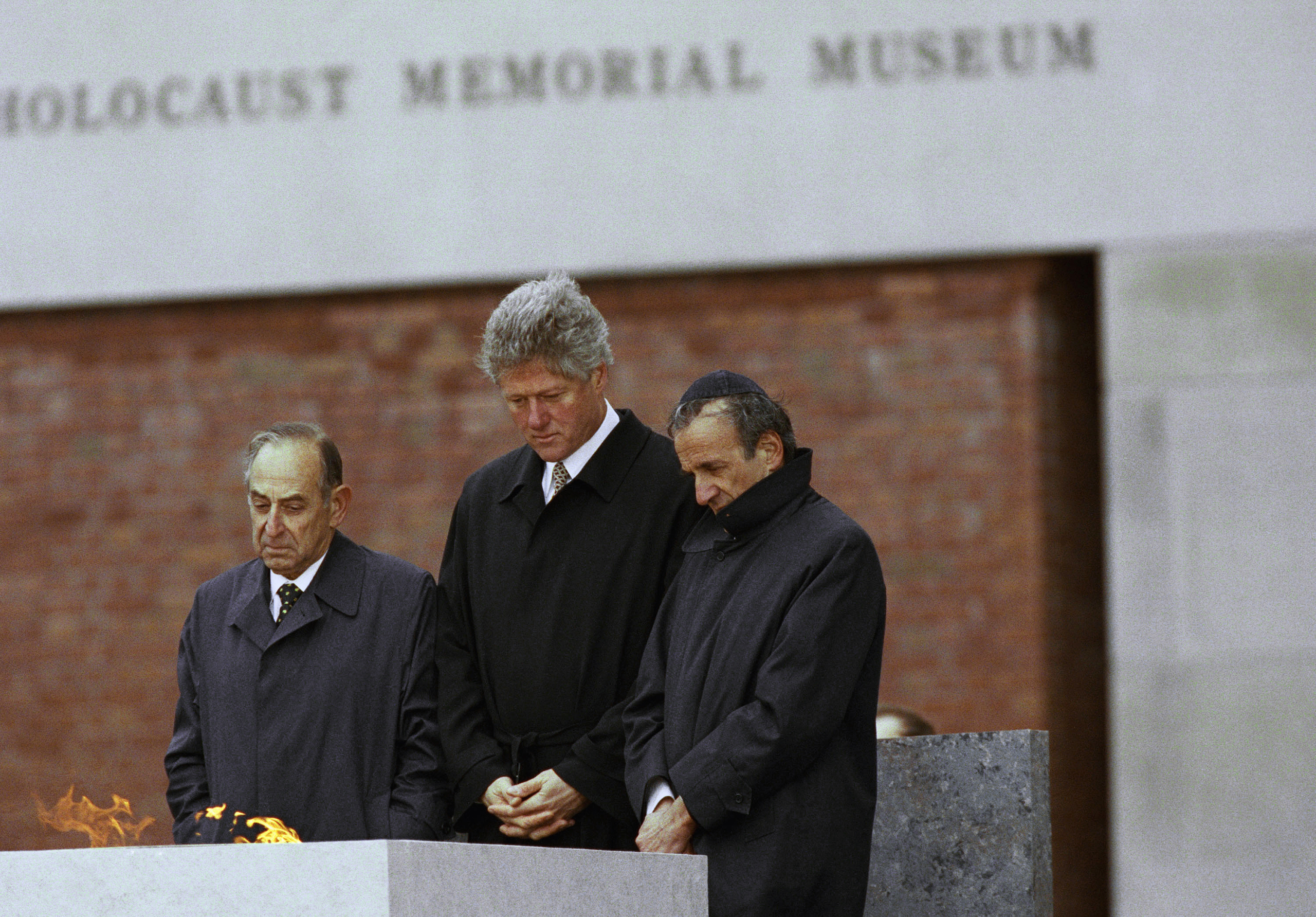 President Bill Clinton, center, along with Bud Meyerhoff, left, chairman of the U.S. Holocaust Council, and Elie Wiesel, founding chairman of the U.S. Holocaust Memorial Council, pause after lighting an Eternal Flame during the dedication ceremony for the U.S. Holocaust Memorial Museum in Washington on April 22, 1993.