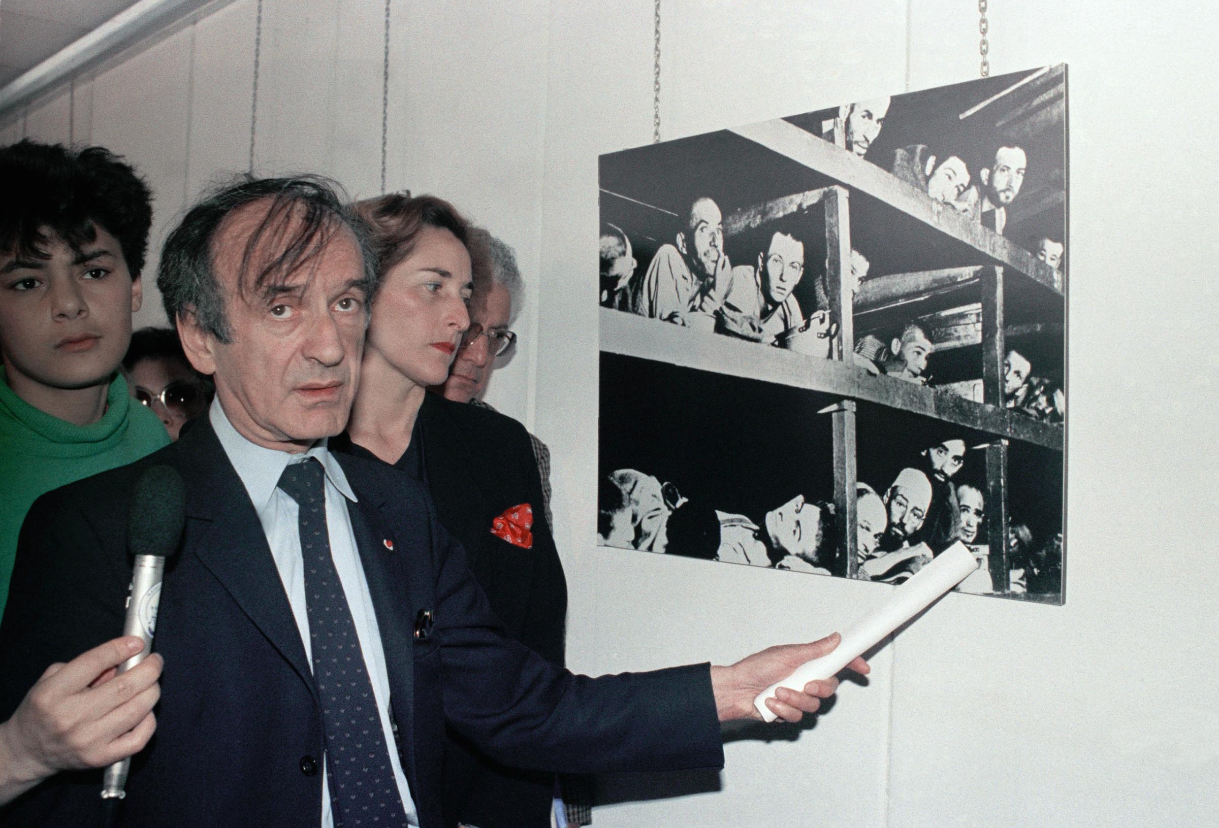 Elie Wiesel, winner of the 1986 Nobel Peace Prize, points to himself in a photo of prisoners at the Buchenwald concentration camp a few days after U.S. troops liberated it, at the Holocaust Memorial in Lyon, France, on June 2, 1987.