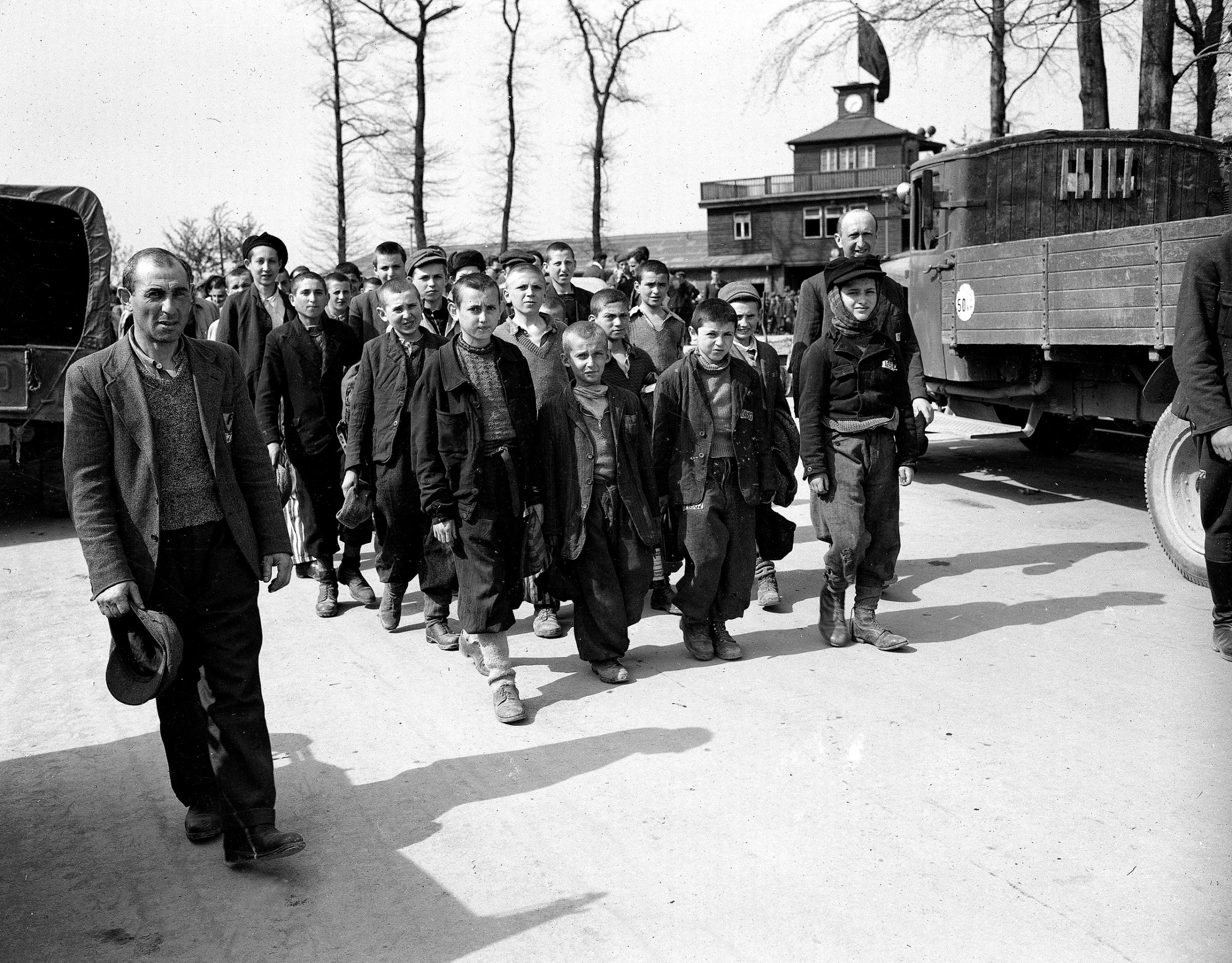 Children and other prisoners liberated by the 3rd U.S. Army march from Buchenwald concentration camp near Weimar, Germany, in April 1945. The freed prisoners are walking to an American hospital to receive treatment. The tall youth in the line at left, fourth from the front, is Elie Wiesel.