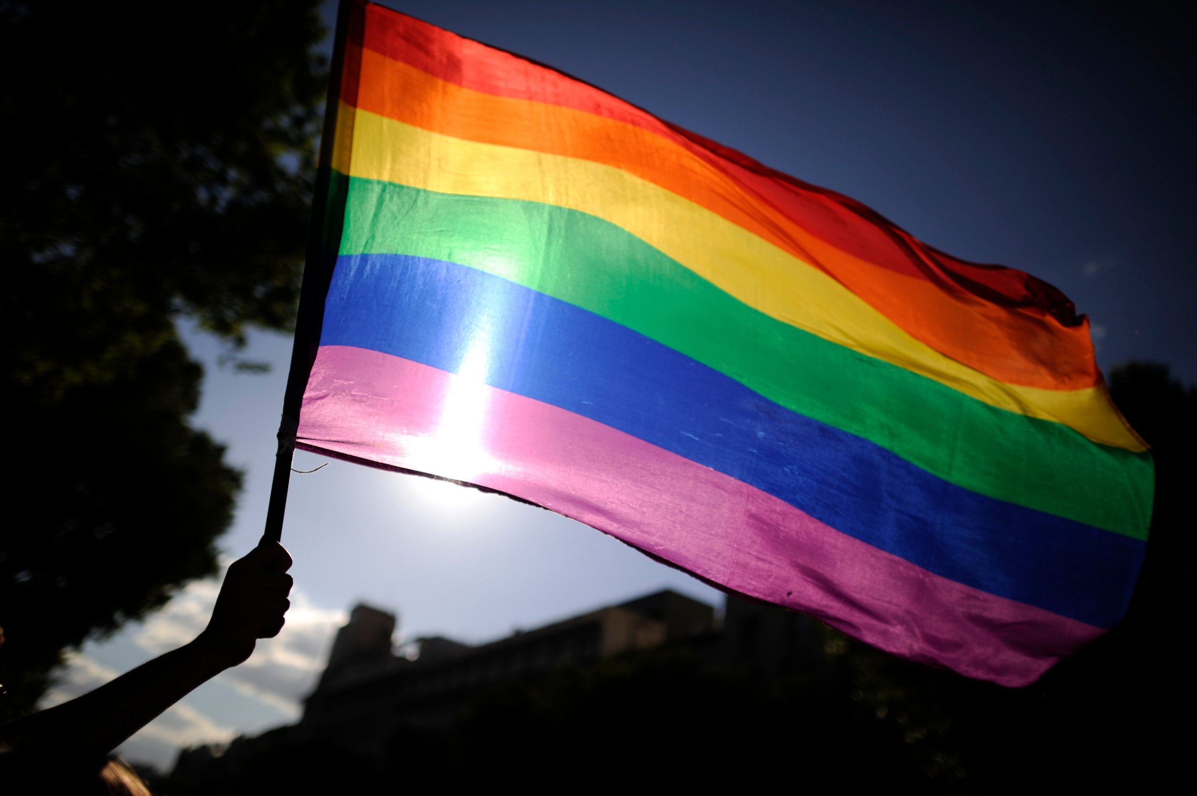 A participants holds a rainbow flag duri