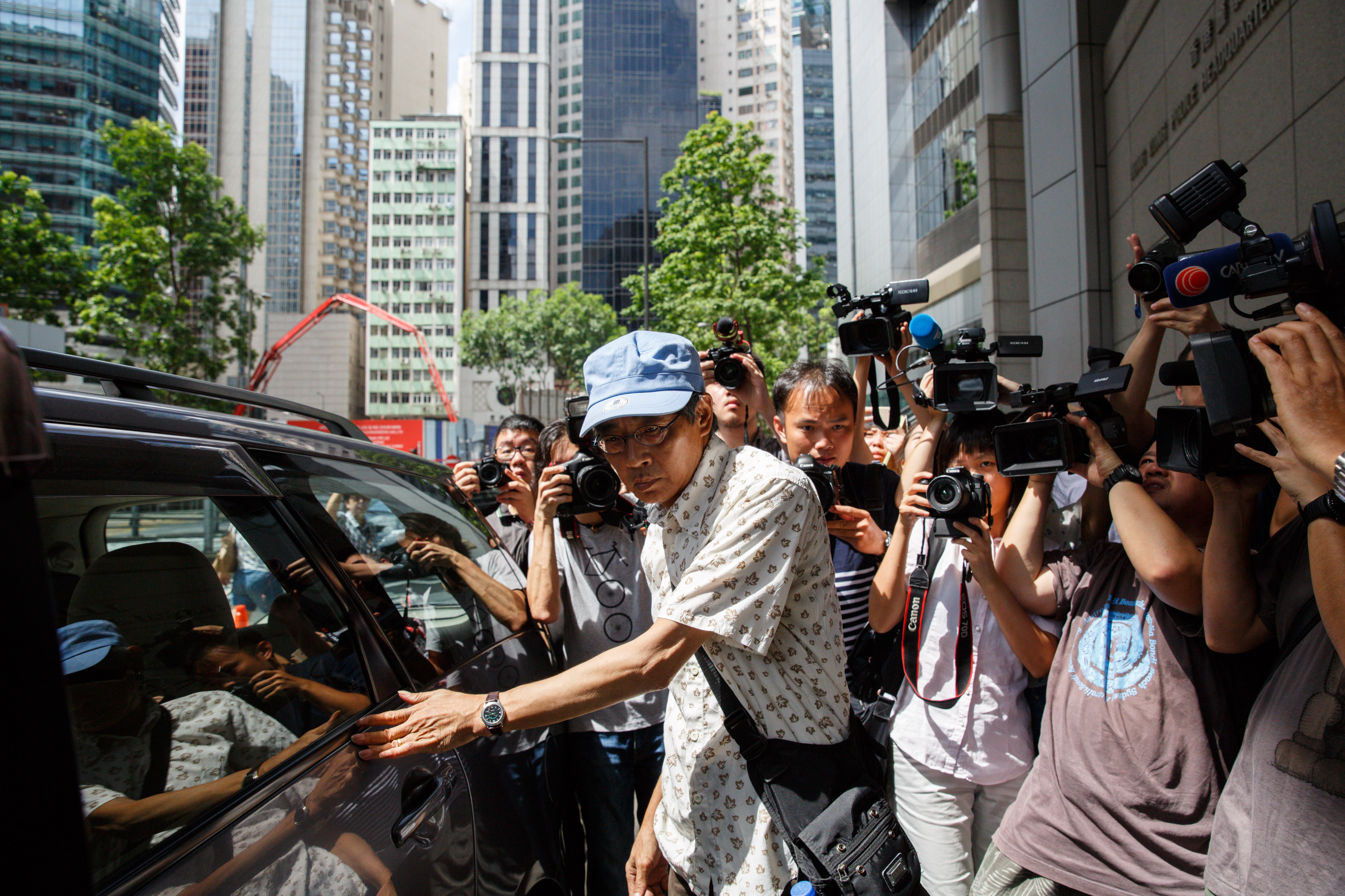 Previously missing Hong Kong bookseller Lam Wing-kee, center, arrives at Wanchai police station to report to the police in Hong Kong on June 27, 2016 (Anthony Wallace—;AFP/Getty Images)