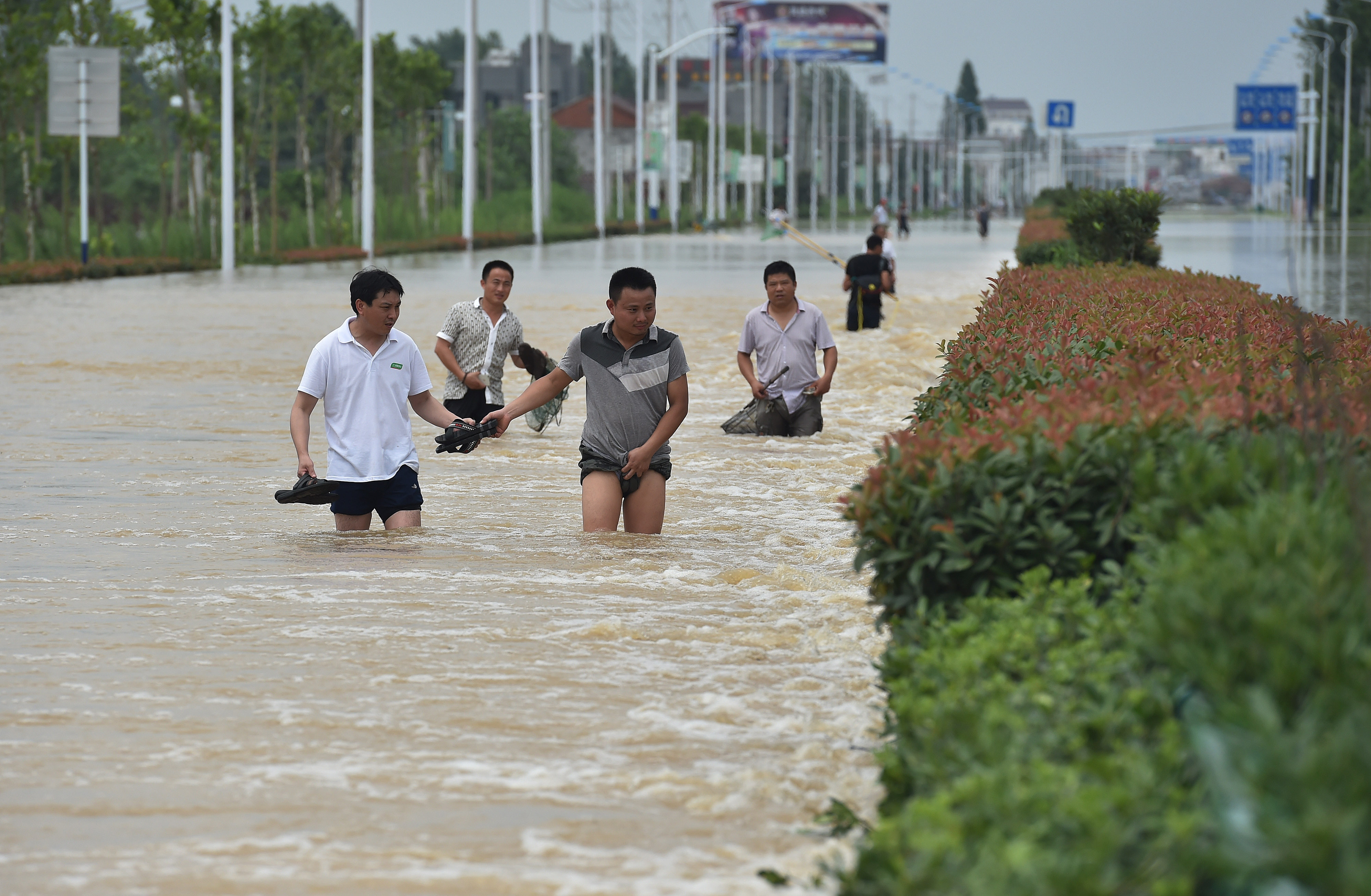 Residents walk in the flood caused by a rainstorm in Shucheng county, China's Anhui province, on July 3, 2016 (VCG/Getty Images)