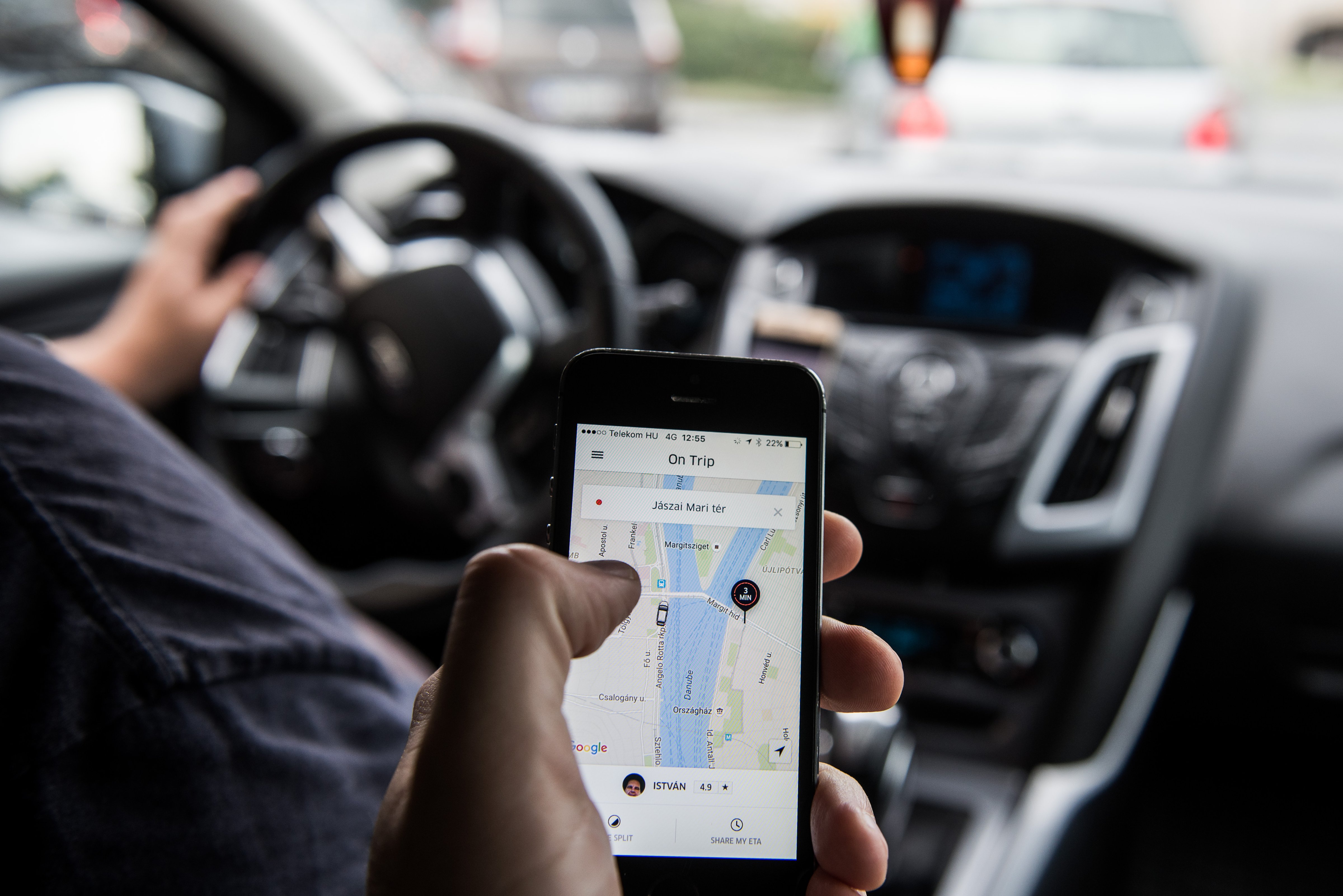 A passenger holds an iPhone displaying the Uber car service taxi application journey progress screen in Budapest, Hungary, on Wednesday, July 13, 2016. (Bloomberg via Getty Images)