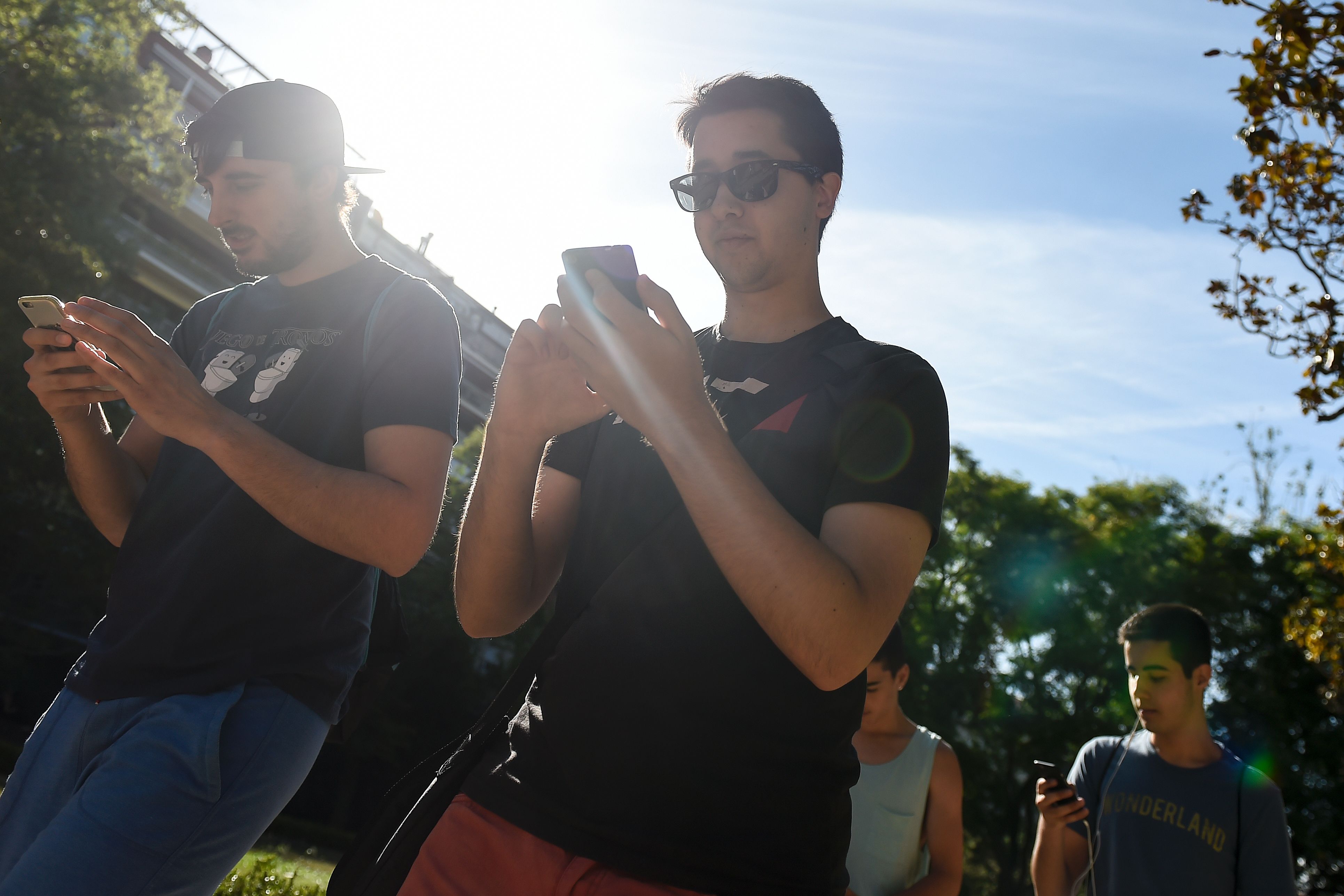 Gamers use the Pokemon Go application on their mobile phones while walking in a Barcelona park, on July 14, 2016. (Josep Lago—AFP/Getty Images)