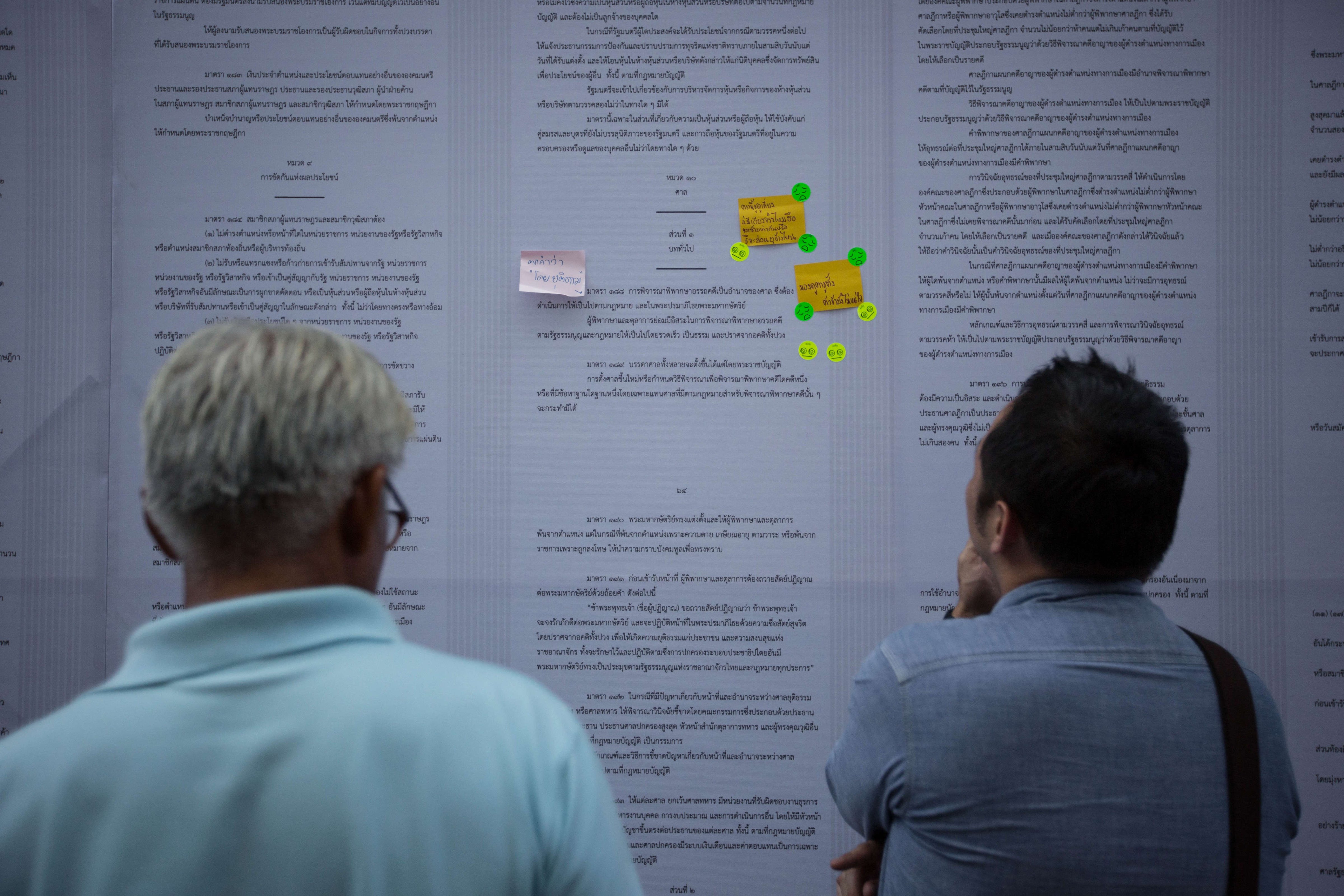 People read the new draft constitution displayed on the wall during the VOTE NO campaign at Thammasat University. (Guillaume Payen—LightRocket/Getty Images)