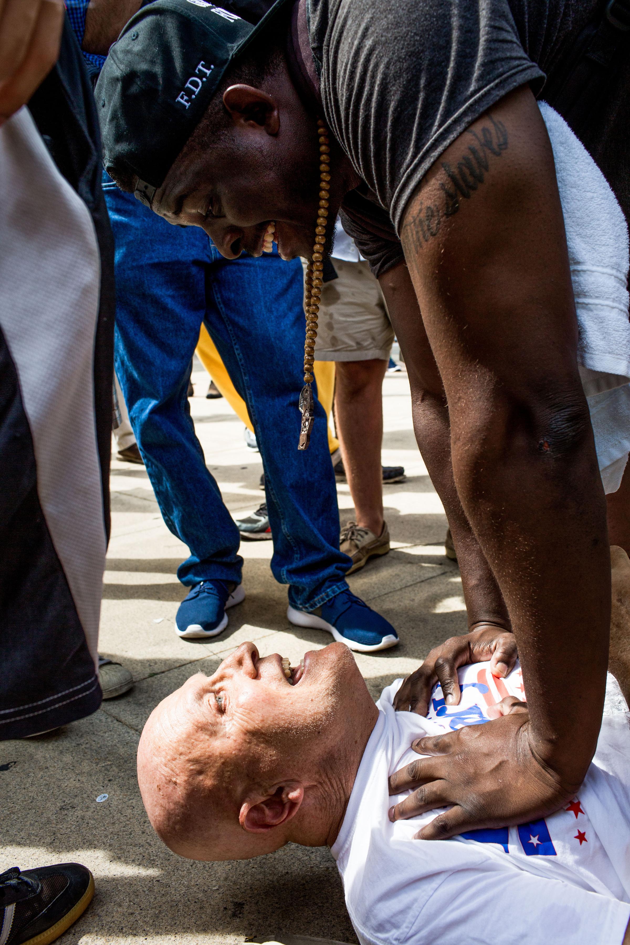 A man accused of assaulting a protestor is held down by another protestor until police arrive. Protesters convened at City Hall in Philadelphia on Tuesday afternoon to watch speaker Jill Stein and protest theDemocratic National Convention at the Wells Fargo Center on July 26, 2016.