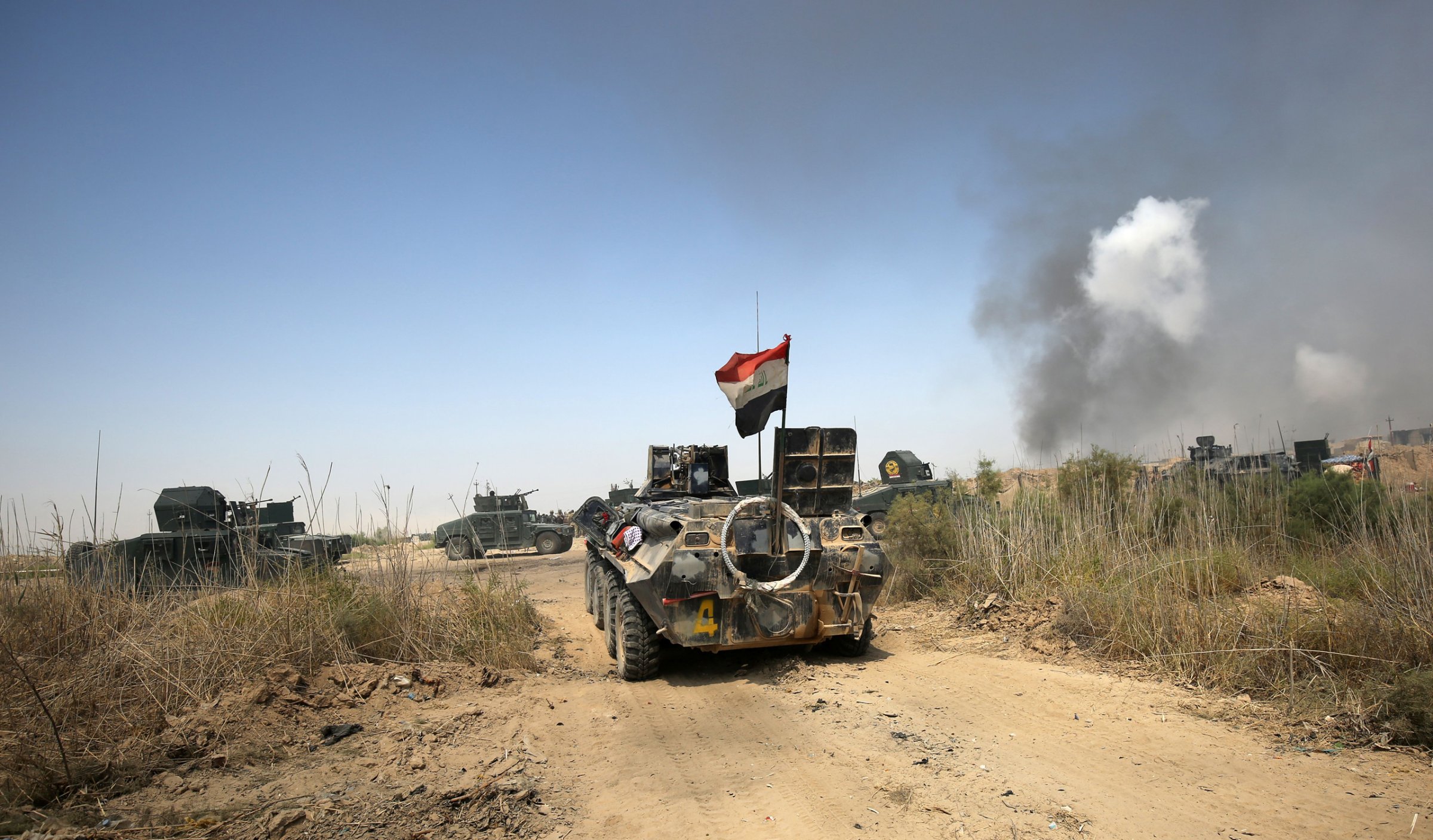 Iraqi government forces drive their armoured vehicles during an operation, backed by air support from the US-led coalition, in Fallujah's southern Shuhada neighbourhood to retake the area from the Islamic State (IS) group on June 15, 2016.