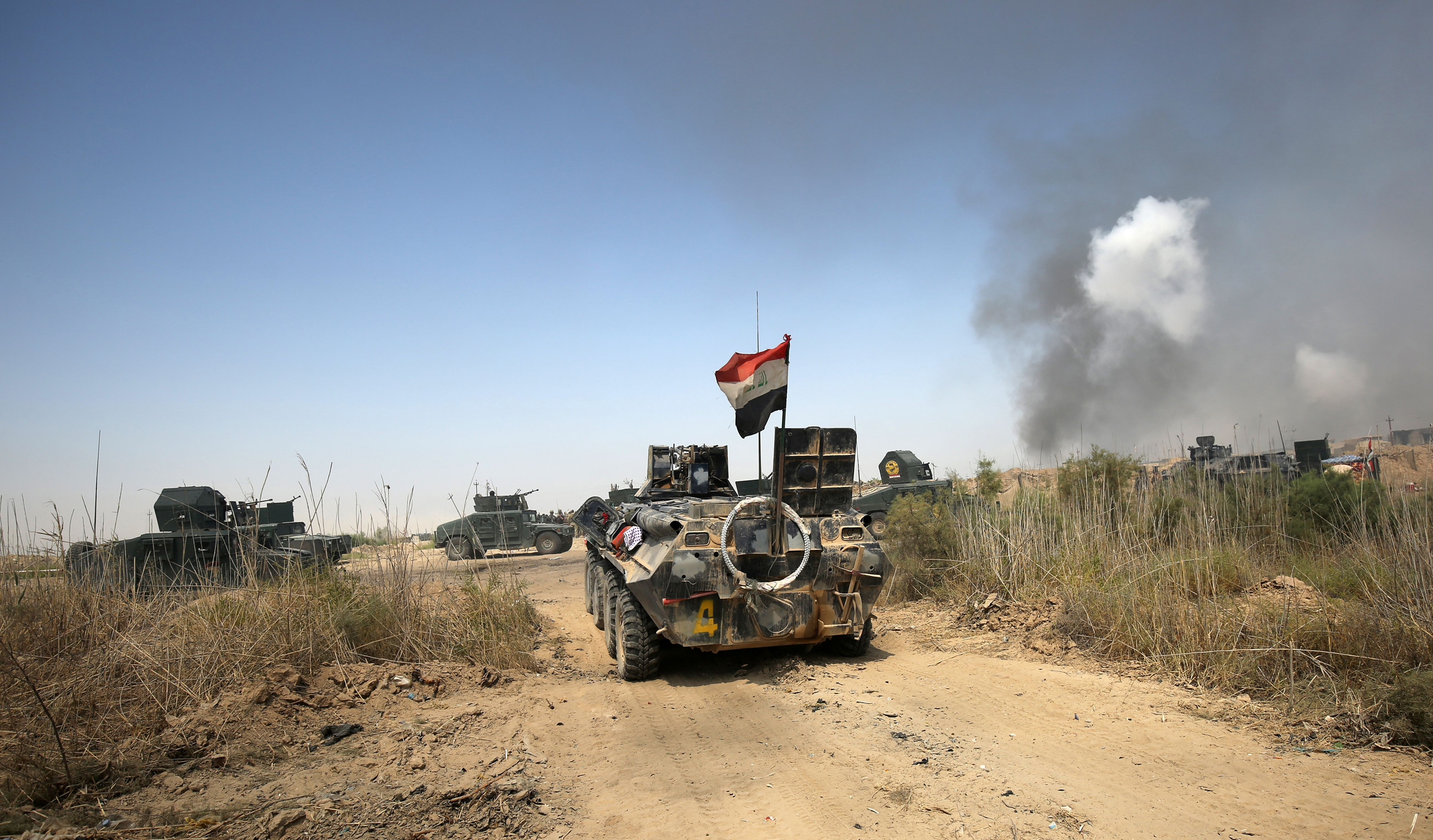 Iraqi government forces drive their armoured vehicles during an operation, backed by air support from the US-led coalition, in Fallujah's southern Shuhada neighbourhood to retake the area from the Islamic State (IS) group on June 15, 2016. (Ahmad Al-Rubaye—AFP/Getty Images)