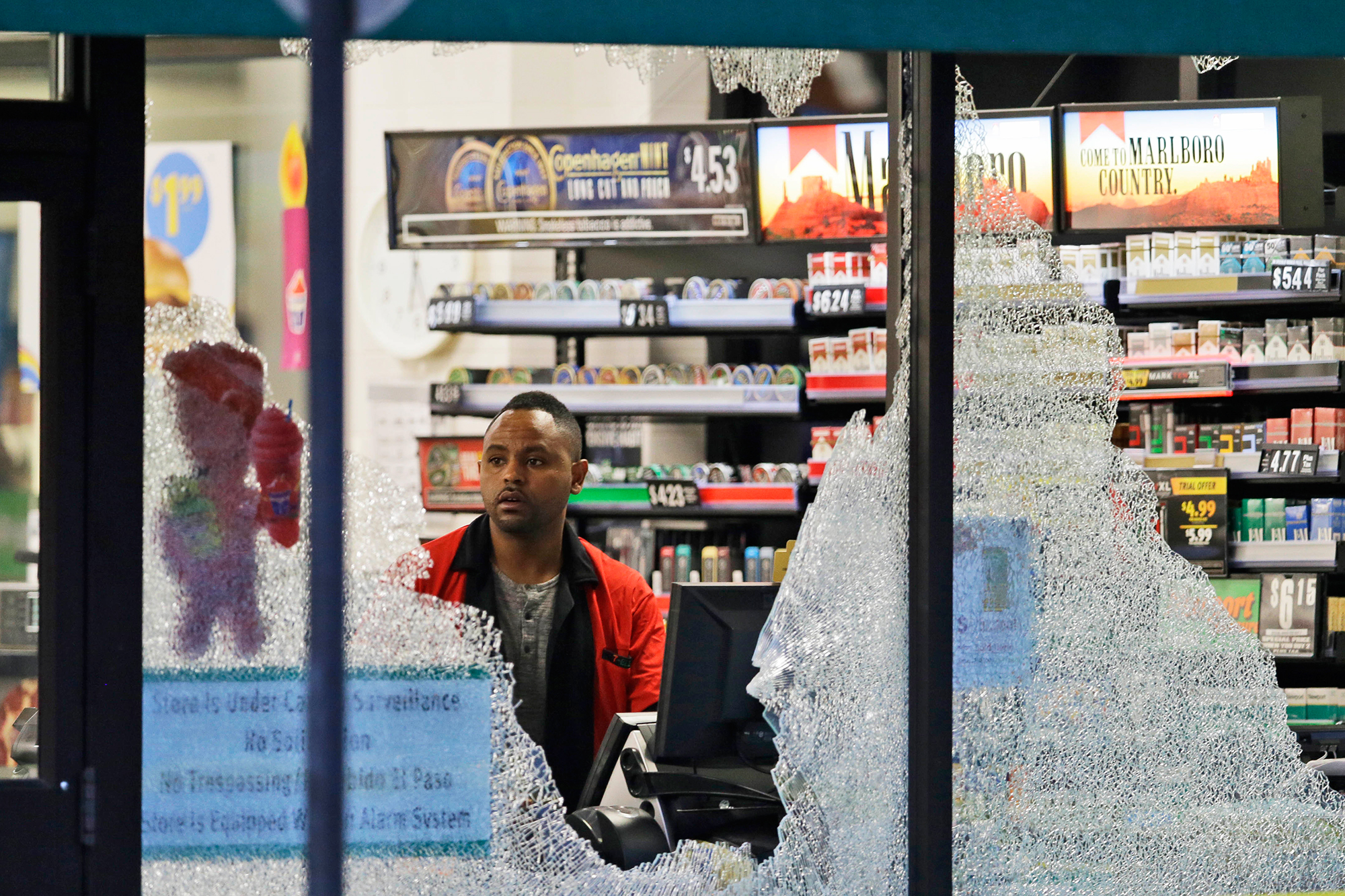 A clerk looks at a store's shattered windows after a sniper shooting in Dallas, on July 8, 2016. (LM Otero—AP)