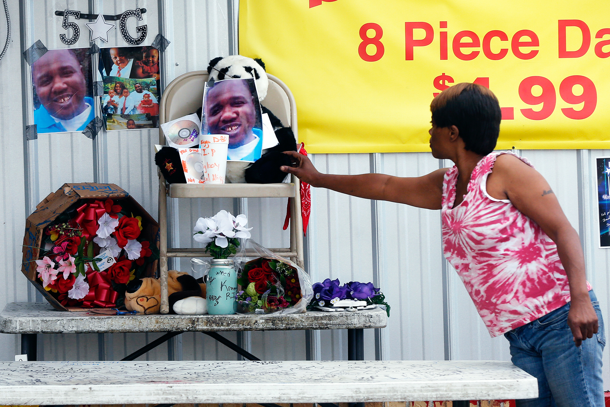 Nishka Johnson touches a makeshift memorial for Alton Sterling, in Baton Rouge, La., on July 6, 2016.