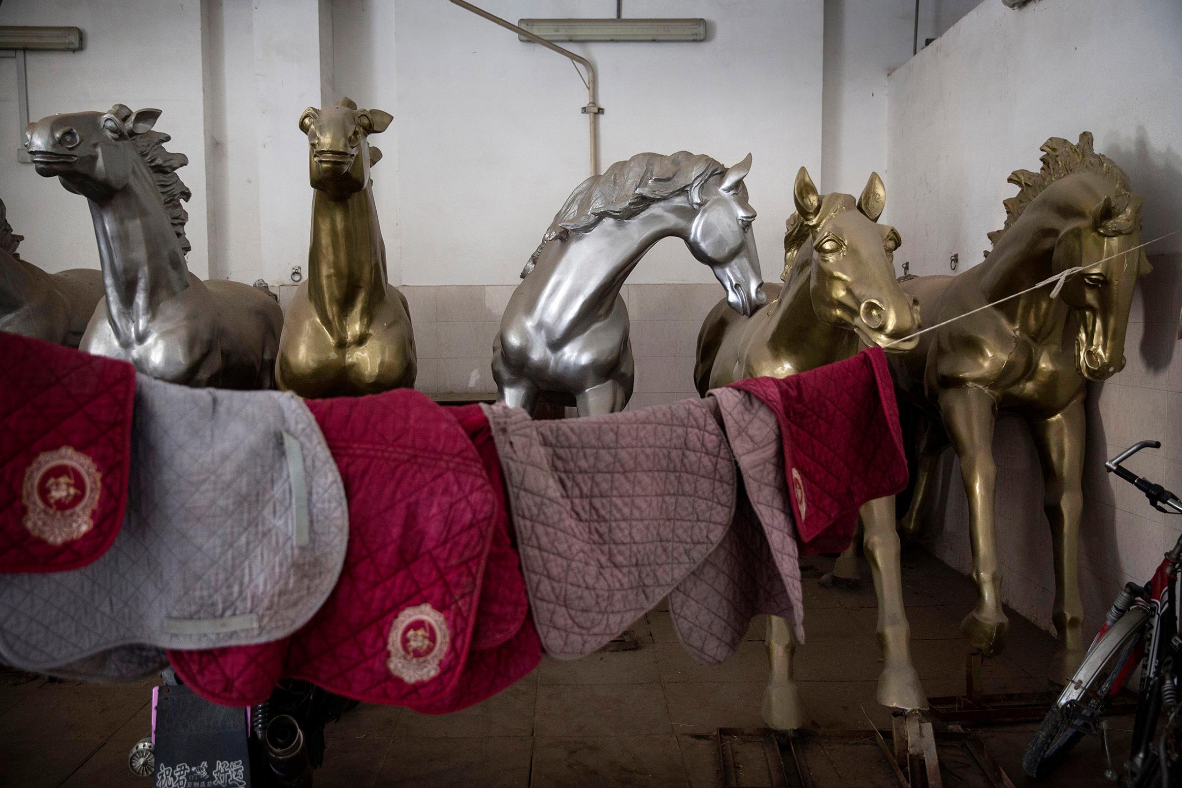 Painted horse sculptures are seen in the stables at the Tianjin Goldin Metropolitan Polo Club in Tianjin, China, on July 16, 2016.