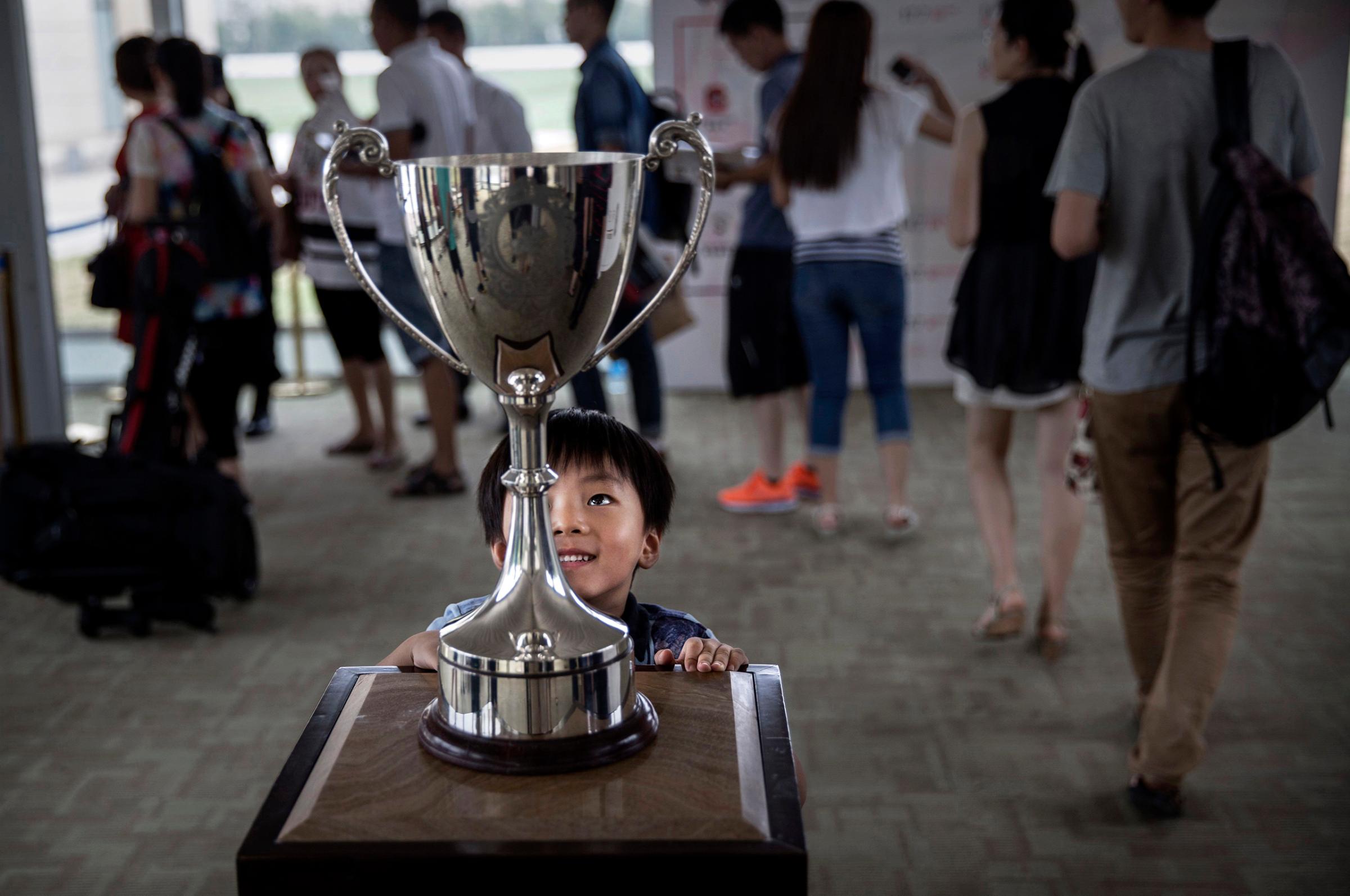 A boy looks at the cup before a match at the Tianjin Goldin Metropolitan Polo Club in Tianjin, China, on July 17, 2016.