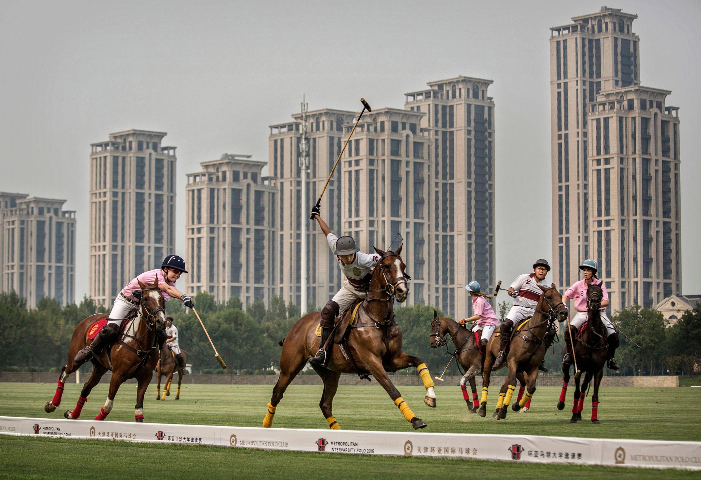 Chinese players from the Metropolitan Polo Club team, in white, and players from the U.S. and Great Britain play an exhibition match at the Tianjin Goldin Metropolitan Polo Club in Tianjin, China, on July 17, 2016.