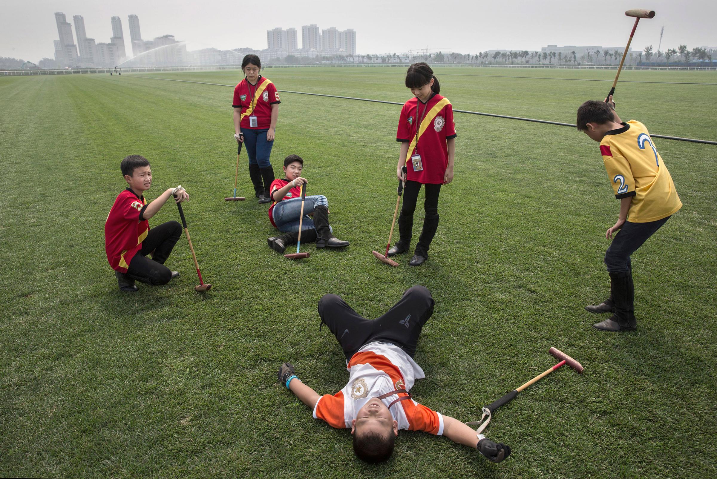 Young Chinese players from the Junior Polo Program take a break during stick and ball training at a summer camp held at the Tianjin Goldin Metropolitan Polo Club in Tianjin, China, on July 17, 2016.