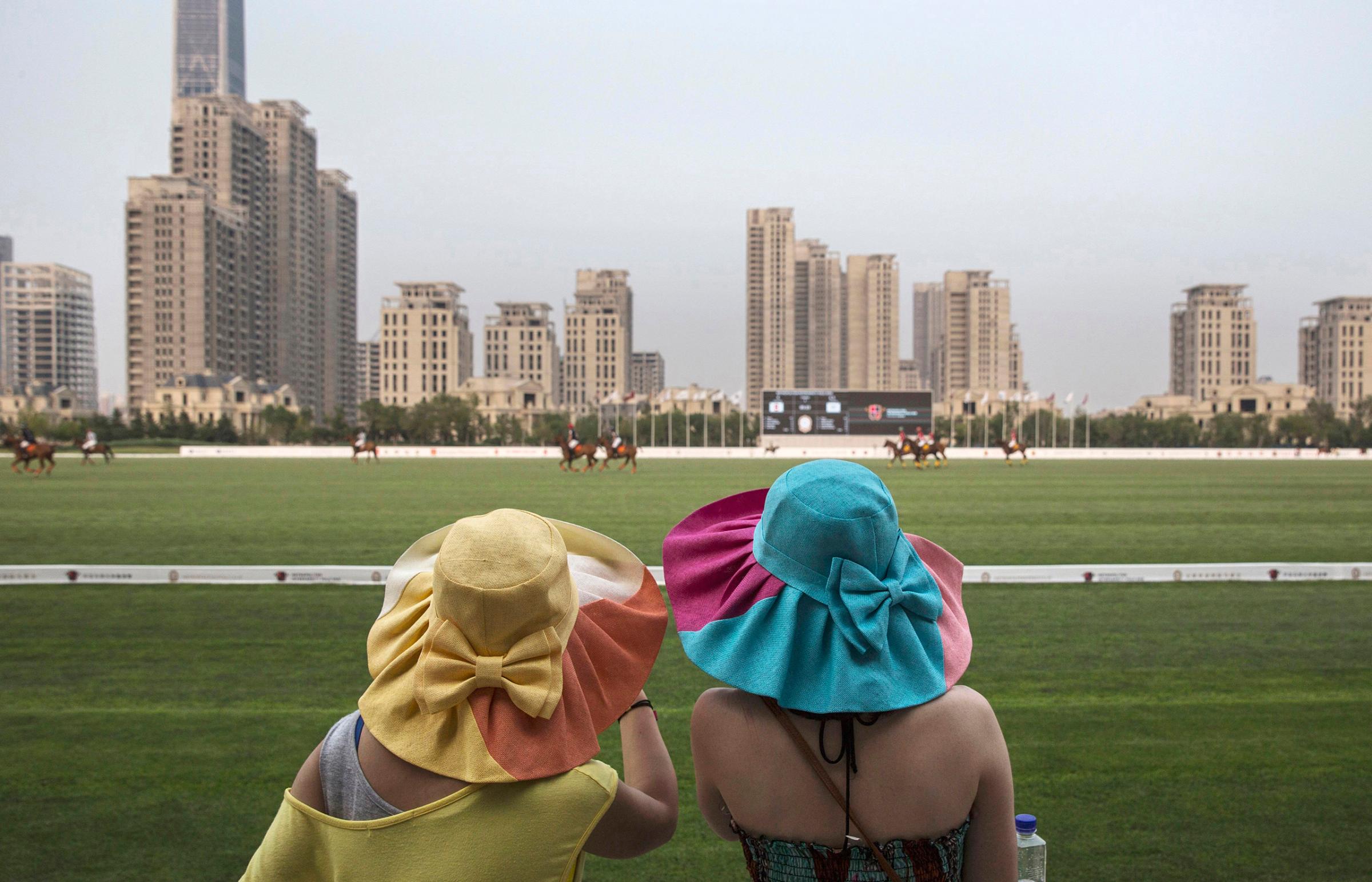 Spectators watch a match between Chinese players from the Metropolitan Polo Club team and those visiting from the U.S. and Britain during the intervarsity tournament at the Tianjin Goldin Metropolitan Polo Club in Tianjin, China, on July 17, 2016.