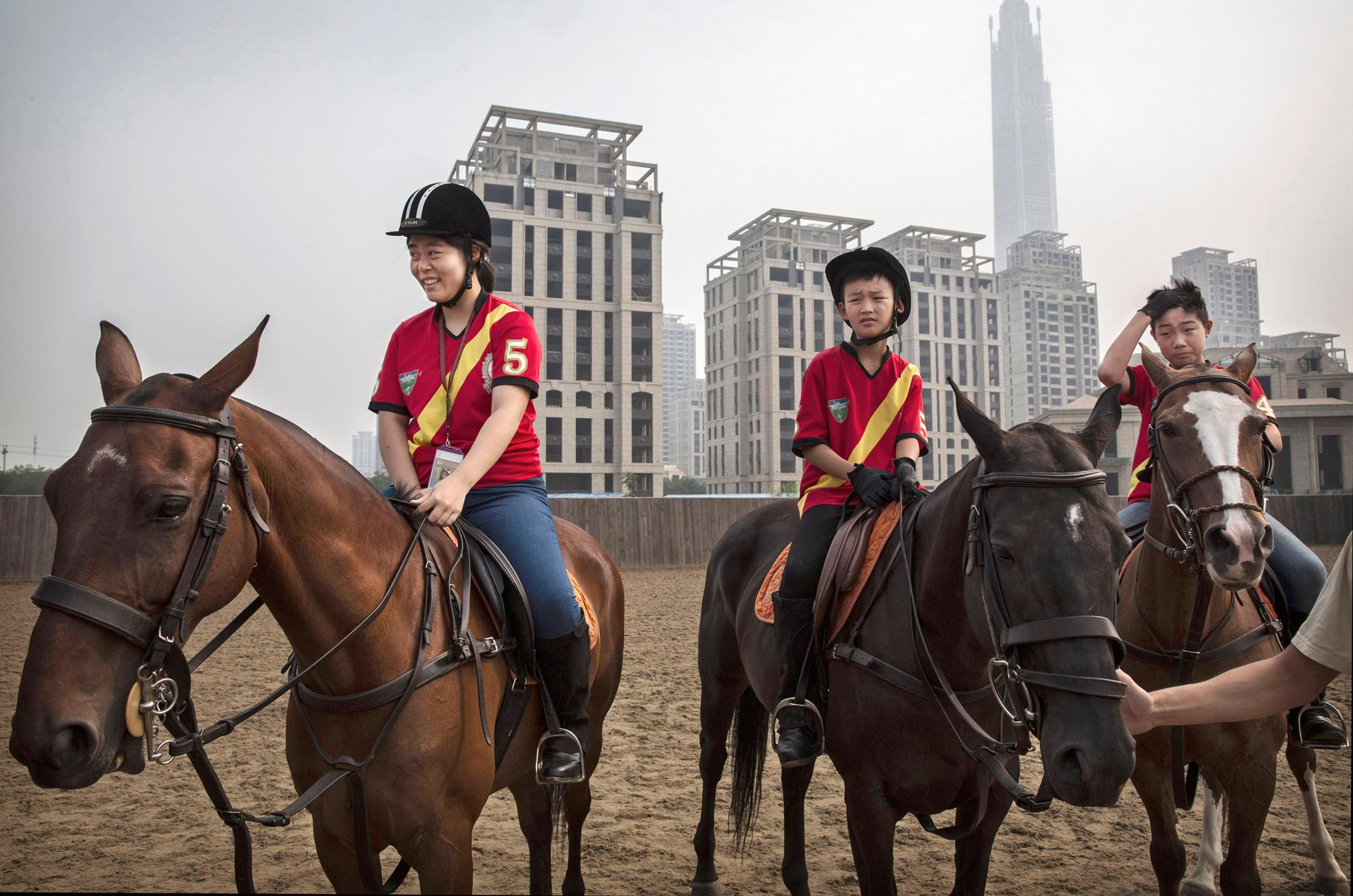 Young Chinese polo players from the Junior Polo Program learn riding skills at a summer training camp held at the Tianjin Goldin Metropolitan Polo Club in Tianjin, China, on July 17, 2016.