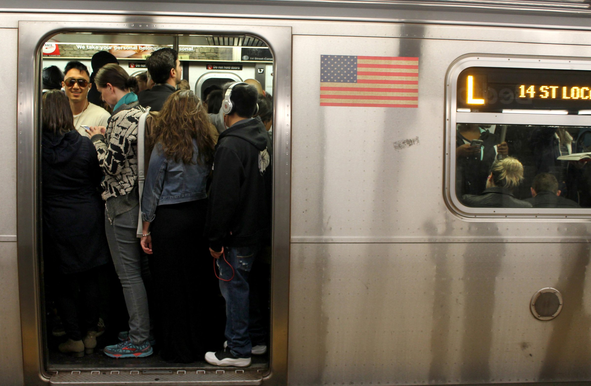 Passengers pack themselves into a crowded L Train on the New York City subway system on May 5, 2016.