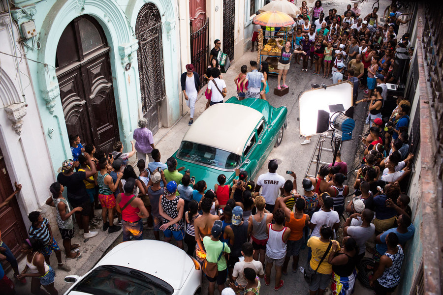 Fans crowd the set of this music video shoot in Old Havana with artists Divan and El Principe. The set includes typical elements of the neighborhood, a fruit stand and a classic American car. 9/24/2015