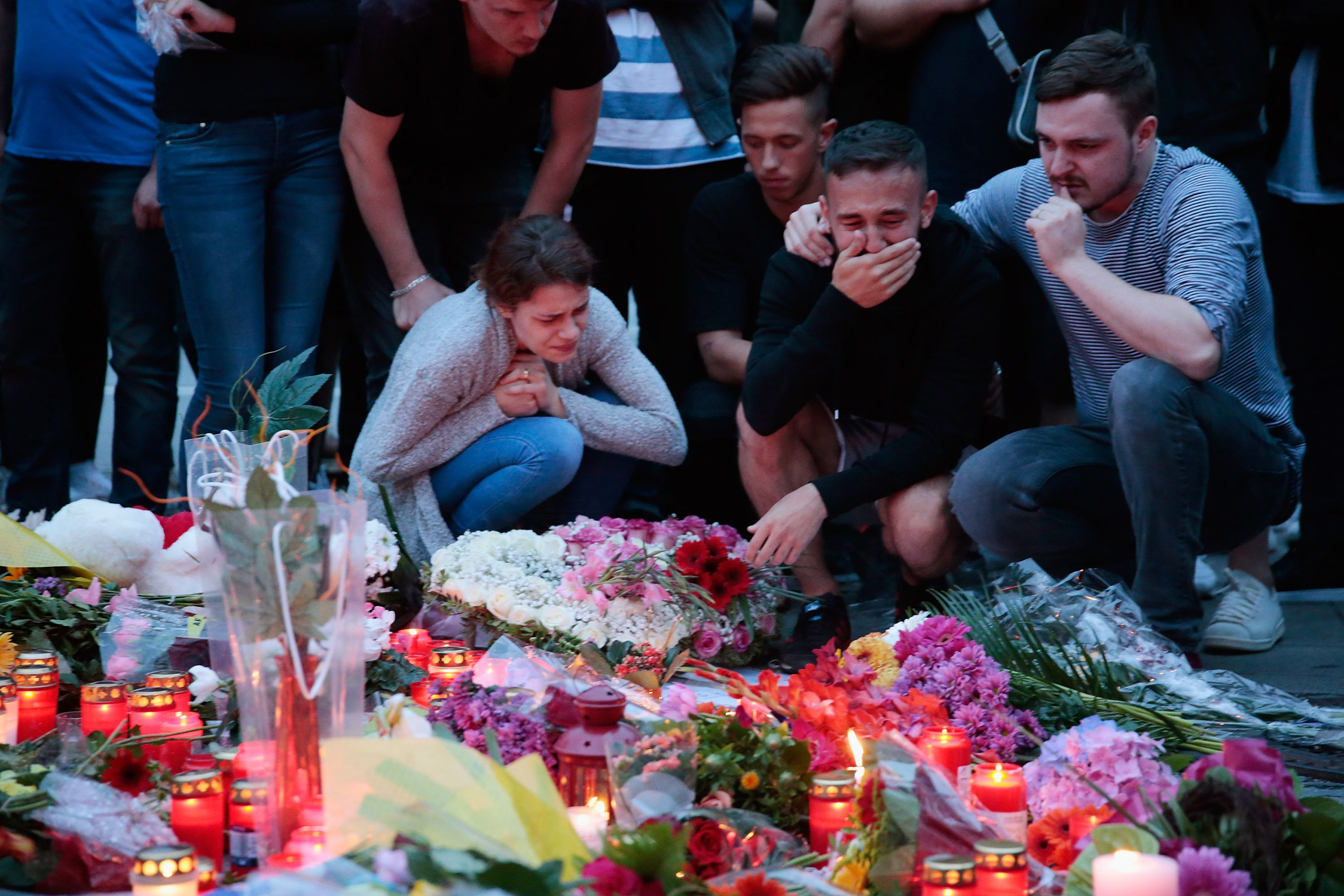People mourn near the crime scene at OEZ shopping center the day after a shooting spree left nine victims dead in Munich, Germany, on July 23, 2016. (Johannes Simon—Getty Images)