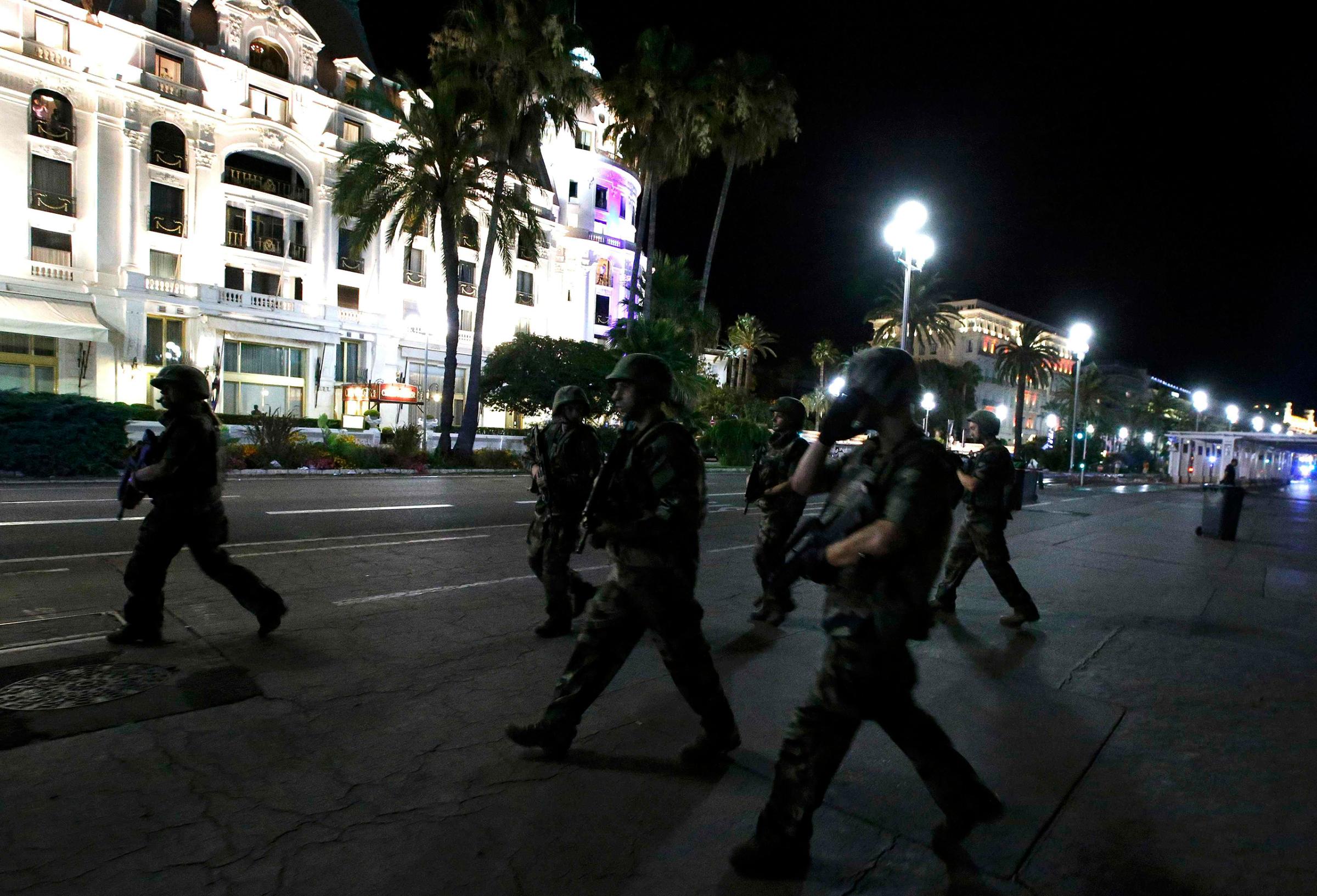 French soldiers advance on the street after at least 70 people were killed in Nice, France, when a truck ran into a crowd celebrating the Bastille Day national holiday on July 14, 2016.
