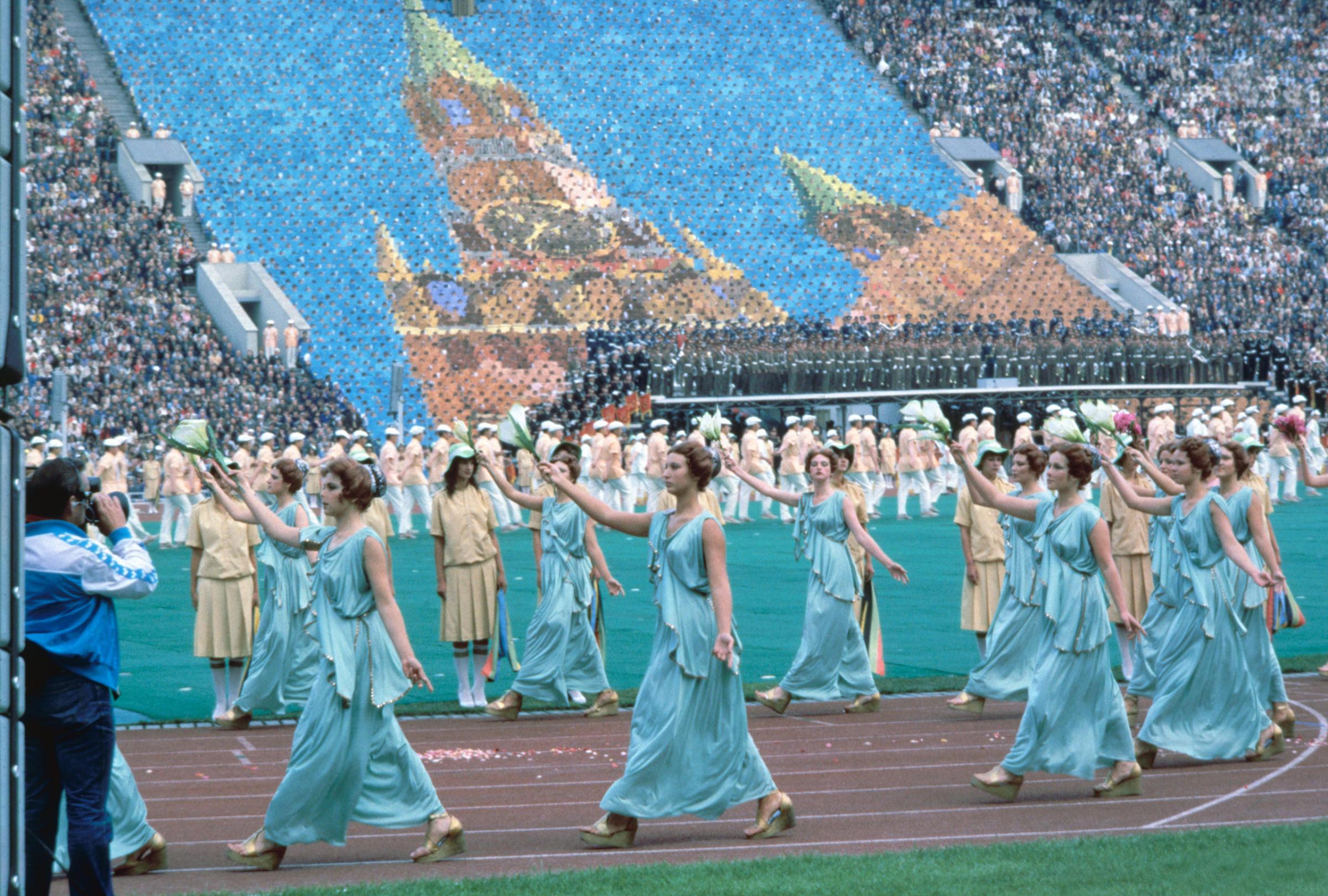 Moscow, 1980Women dressed in Greek costumes form a procession in front of a human mosaic depicting the Kremlin.