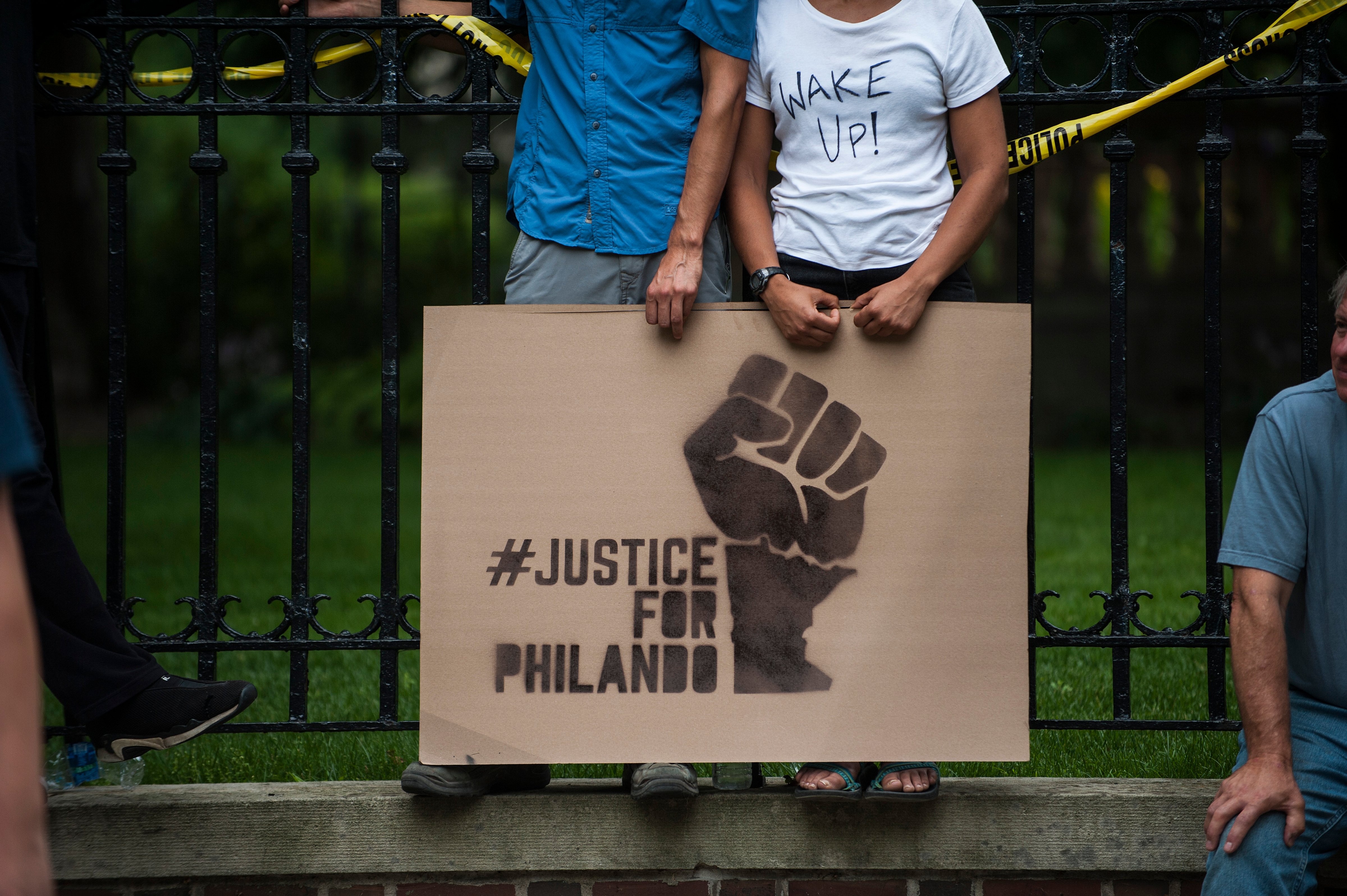 A couple hold a sign protesting the killing of Philando Castile outside the Governor's Mansion on July 7, 2016 in St. Paul, Minnesota. (Stephen Maturen—Getty Images)