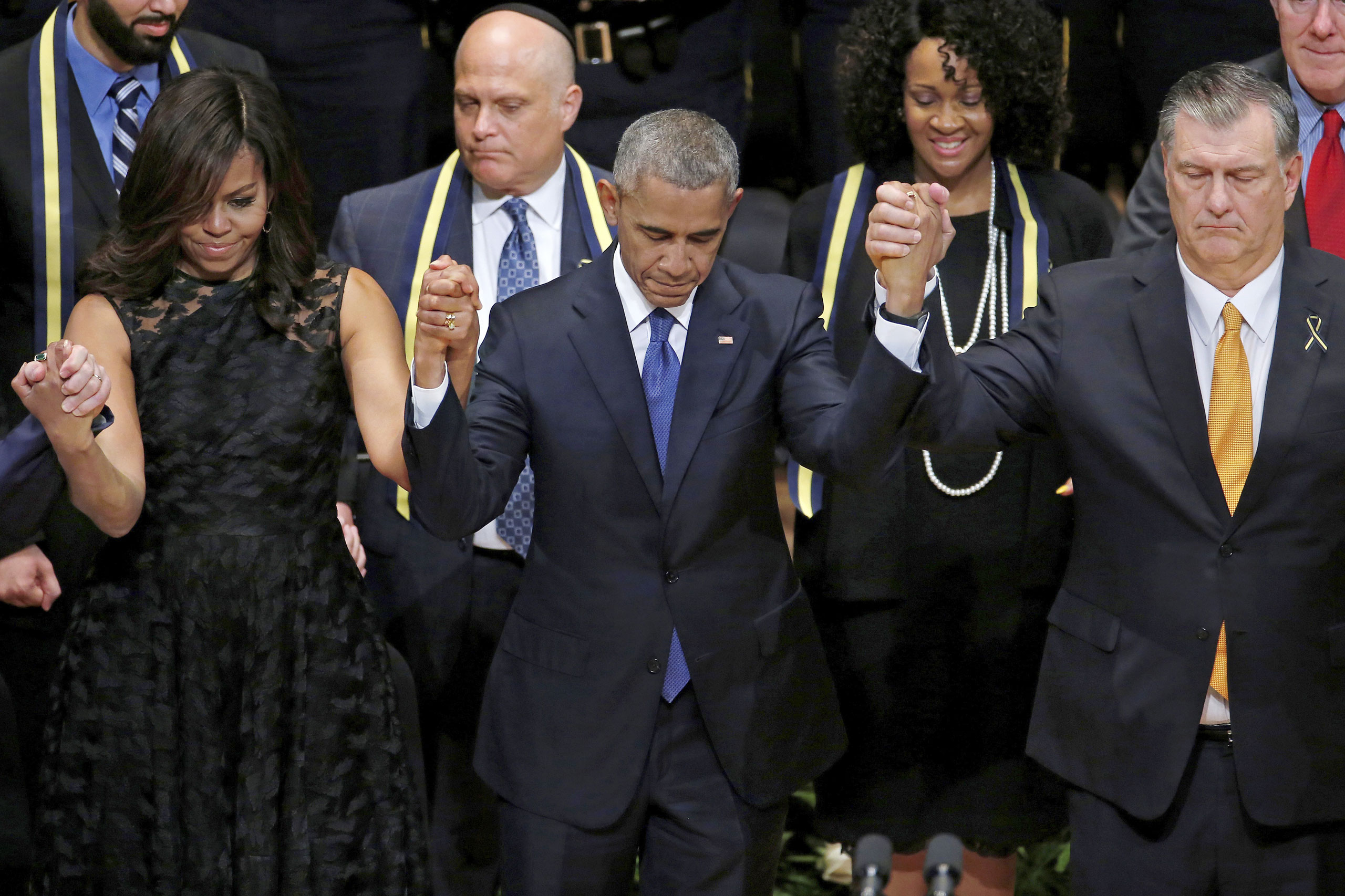 At a service for the five Dallas police officers killed on July 8, President Obama, with Michelle Obama and Dallas Mayor Mike Rawlings, said he had “spoken at too many memorials” (Carlo Allegri—Reuters)