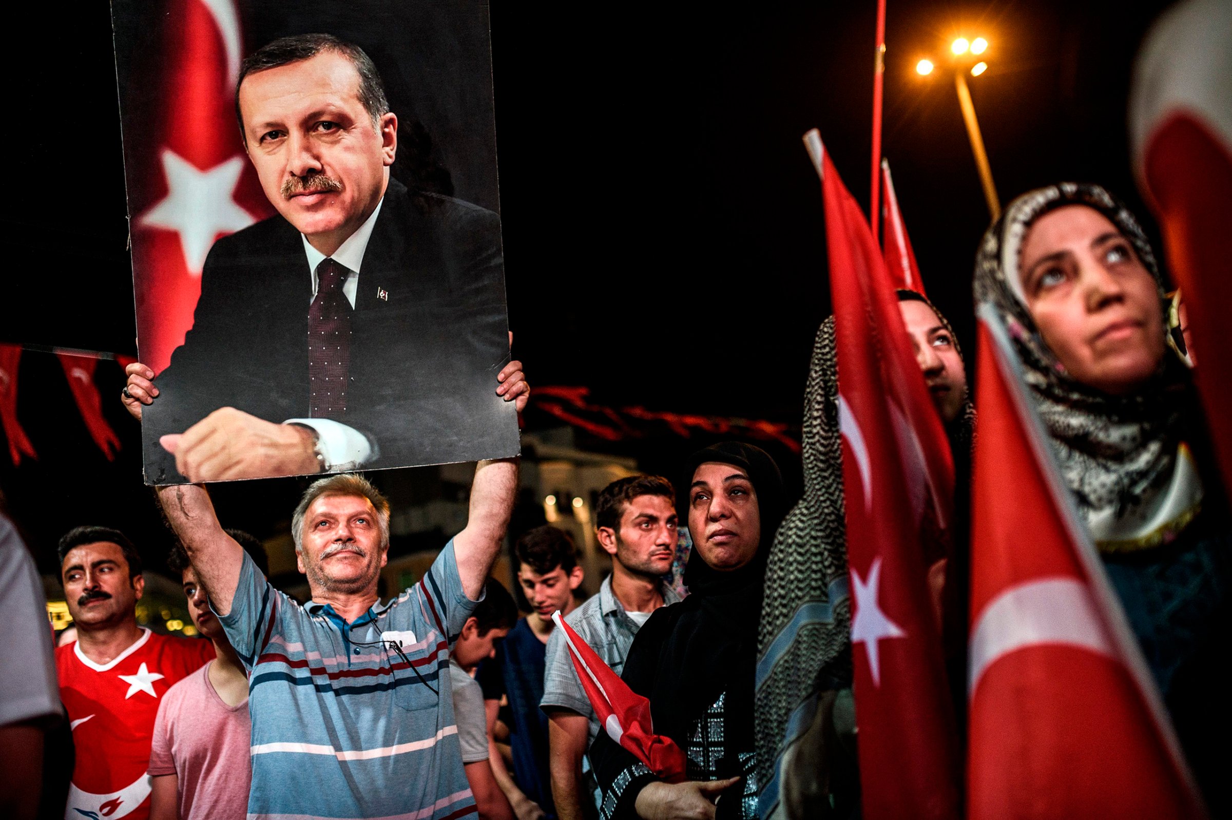 A man holds up a photo of Turkey's President Recep Tayyip Erdogan during a pro-Erdogan rally in Taksim Square in Istanbul on July 22, 2016.