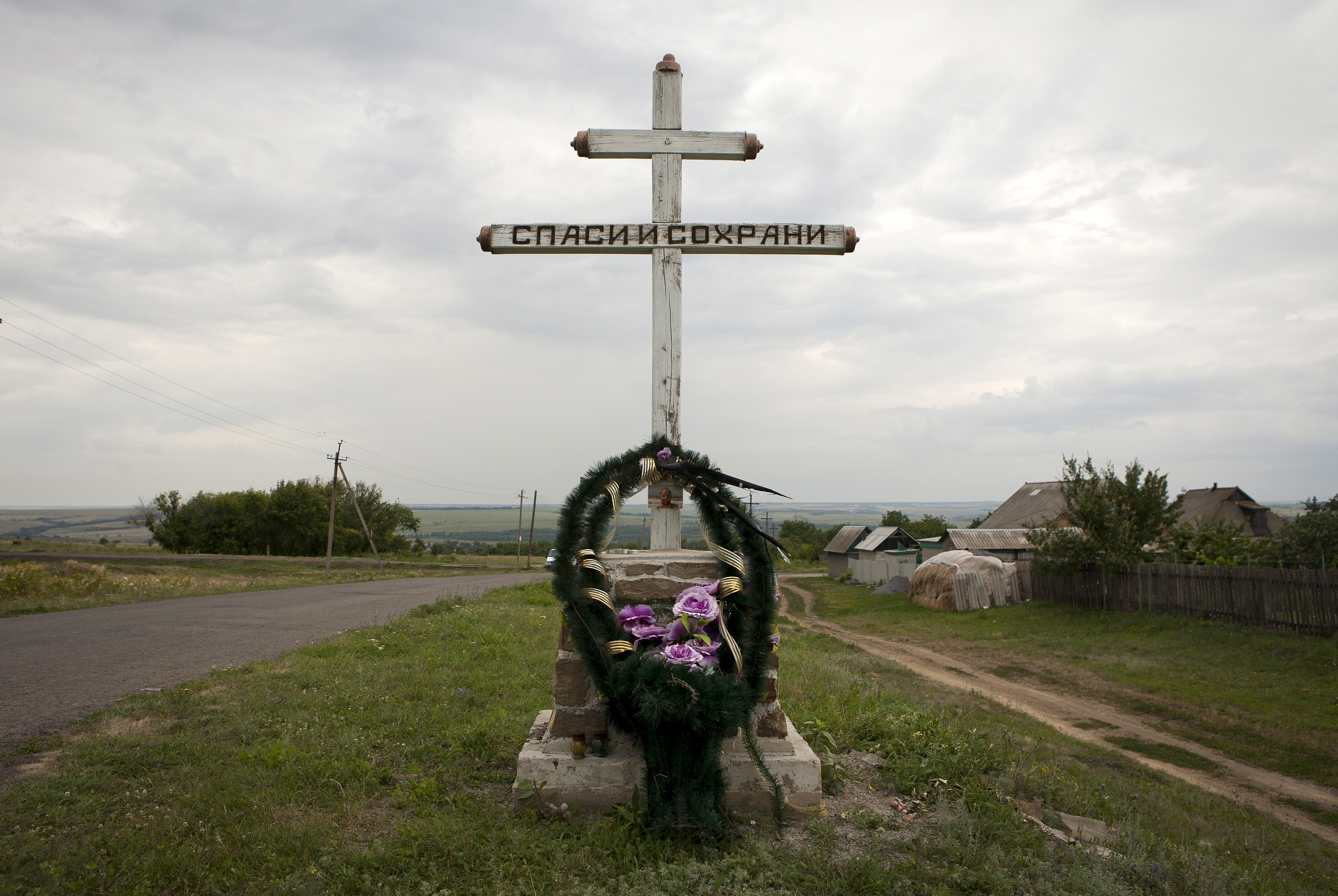 A wreath is placed on a cross with an inscription that reads "Save and protect" next to the site of the downed Malaysia Airlines flight MH17, near the village of Hrabove (Grabovo) in Donetsk region, eastern Ukraine, July 14, 2015. (Kazbek Basayev—Reuters)