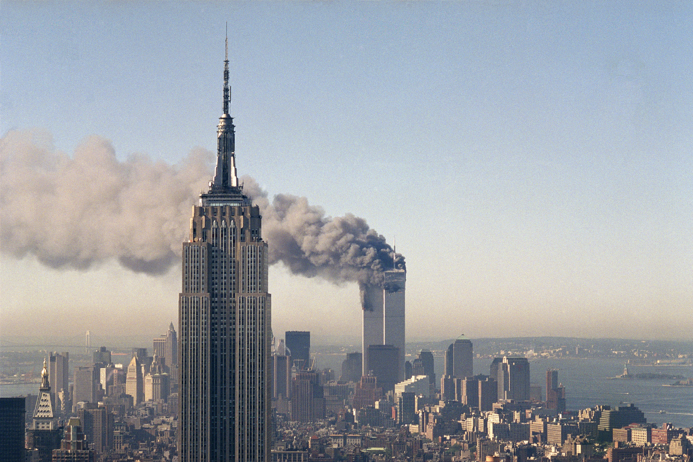 The twin towers of the World Trade Center burn behind the Empire State Building in New York after terrorists crashed two planes into the towers causing both to collapse, Sept. 11, 2001. (Marty Lederhandler—AP)