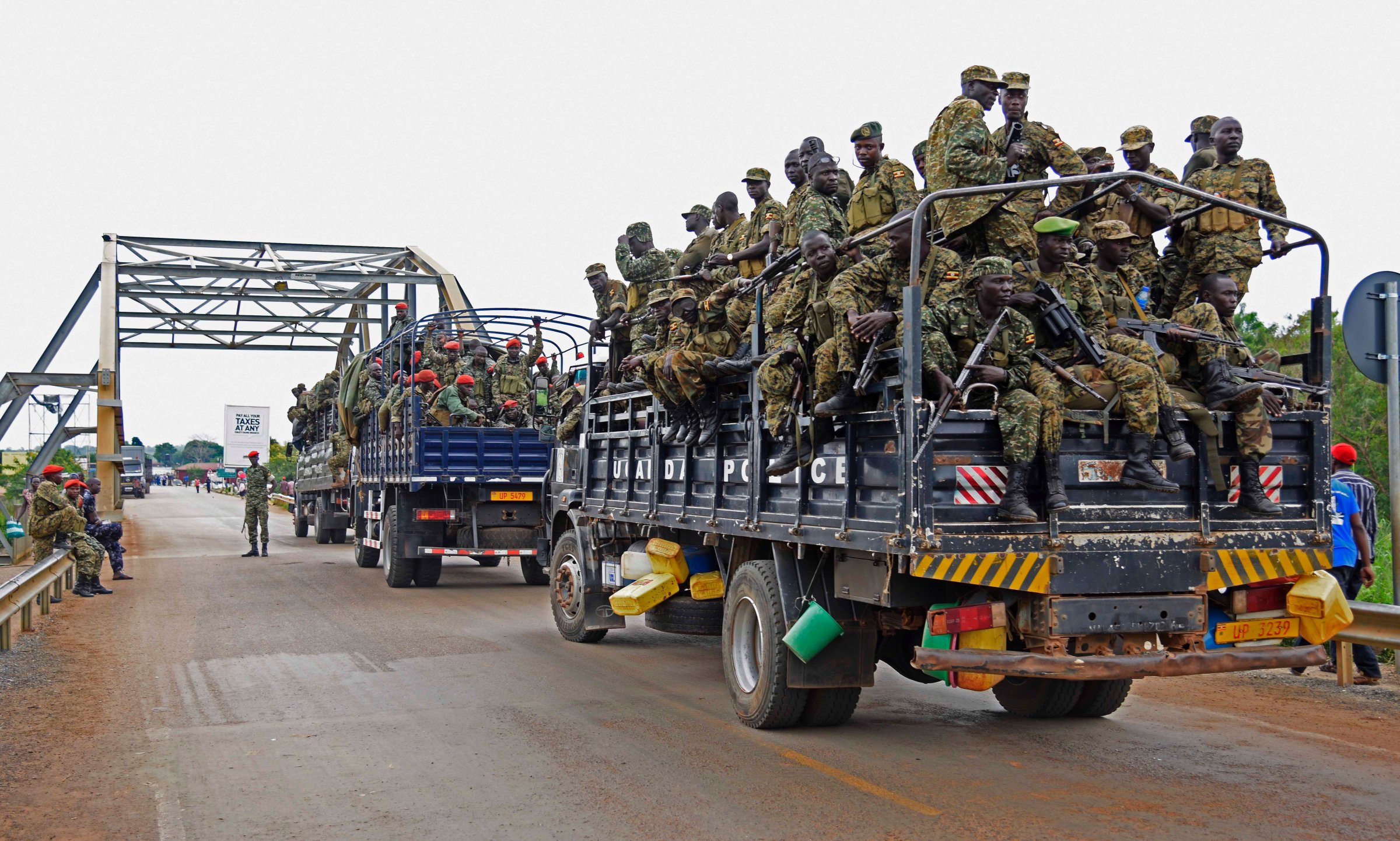 Uganda military personnel are seen atop military and police trucks as they drive towards Juba in South Sudan at Nimule border point on July 14, 2016.