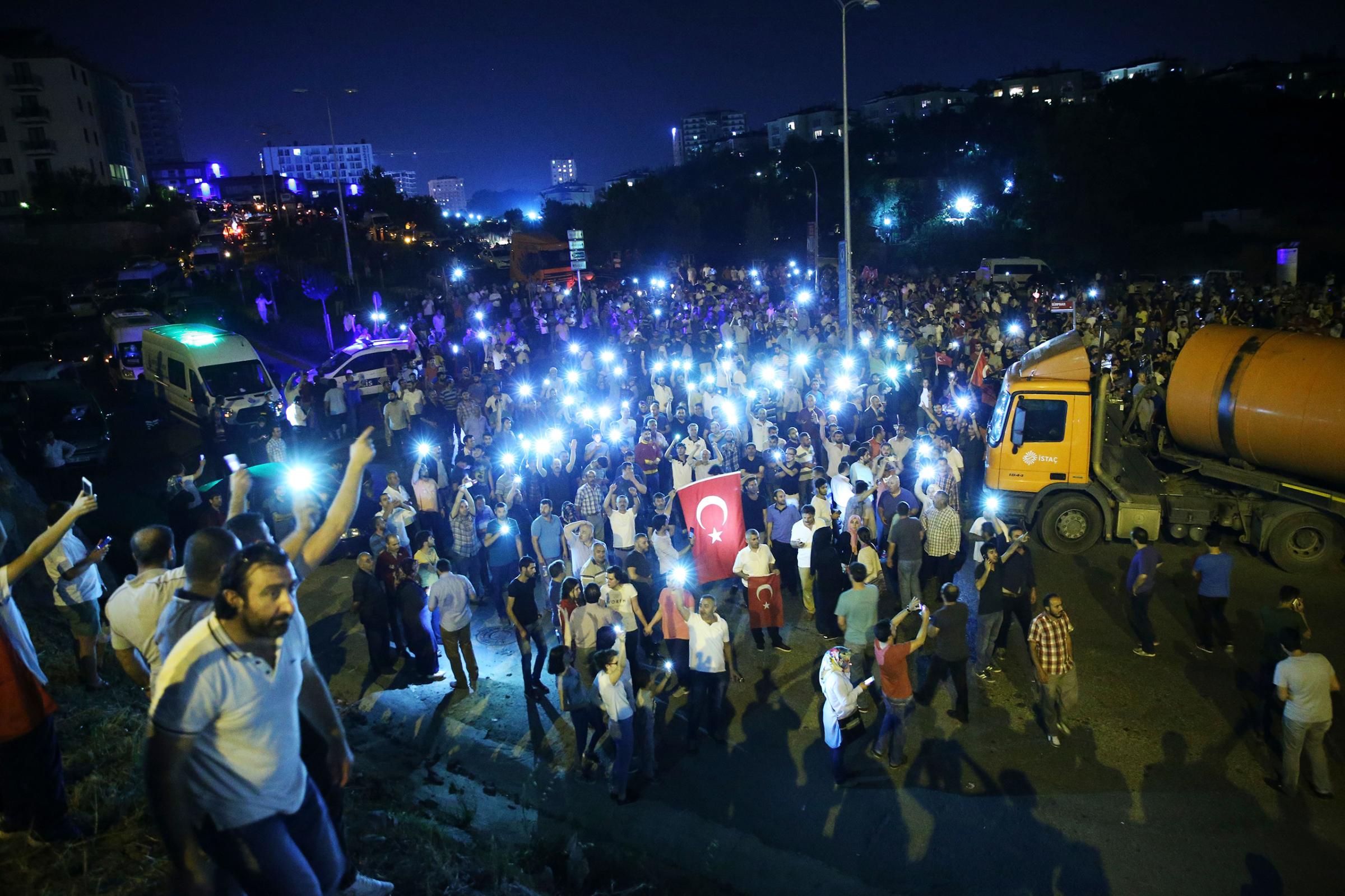 People gather with their mobile phones to react against the military coup attempt in the Tuzla District of Istanbul, Turkey, on July 16, 2016.