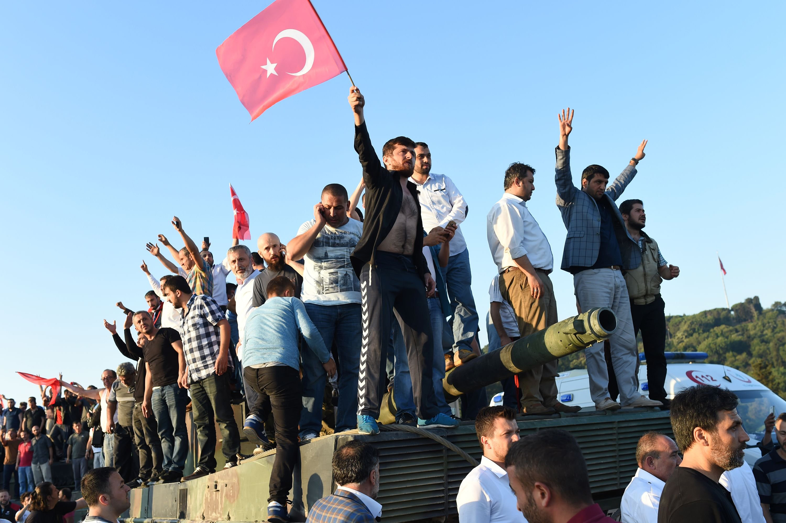 A group of men stand atop a tank the morning after a military coup attempt against the government of Recep Tayyip Erdogan turned violent, killing dozens and leaving hundreds of others detained, on the Bosphorus Bridge in Istanbul, Turkey, on July 16, 2016. (Bulent Kilic—AFP/Getty Images)