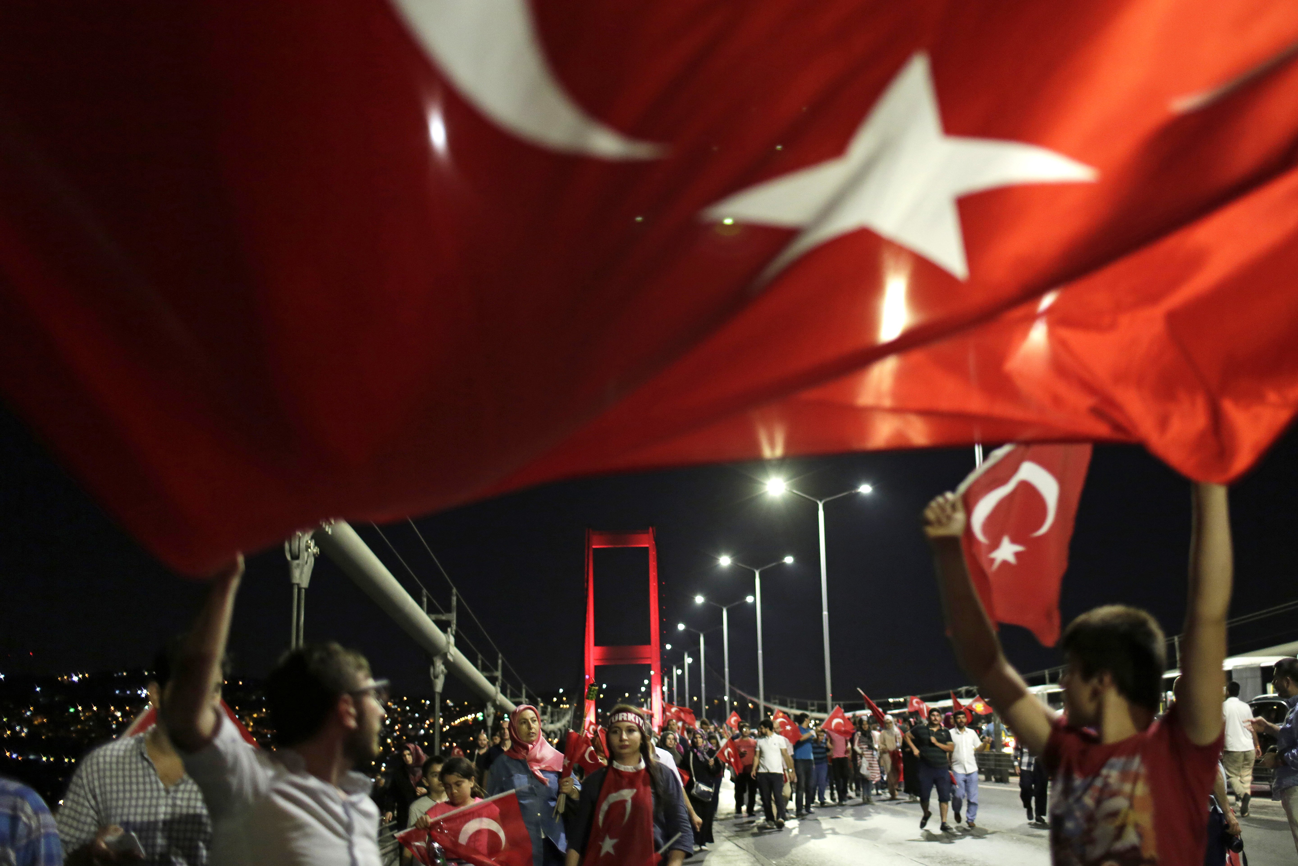 Pro-government supporters wave a Turkish flag as they protest on Istanbul's iconic Bosporus Bridge, late Thursday, July 21, 2016. Turkish lawmakers approved a three-month state of emergency, endorsing new powers for Turkey's President Recep Tayyip Erdogan that would allow him to expand a crackdown that has already included mass arrests and the closure of hundreds of schools, in the wake of the July 15 failed coup. (AP Photo/Petros Giannakouris) (Petros Giannakouris—AP)