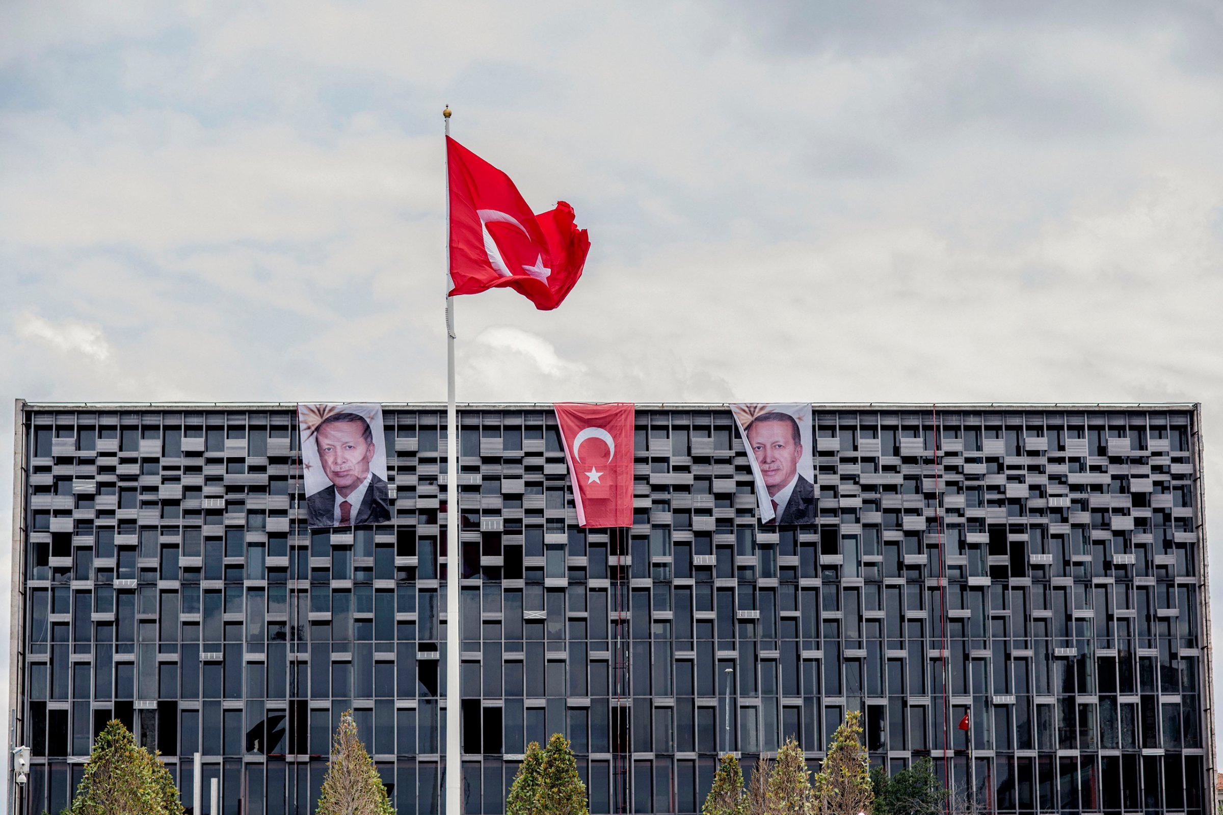 Banners with photographs of President Recep Tayyip Erdogan hang from the roof of a commercial building alongside the national flag in Istanbul, Turkey, on July 18, 2016.