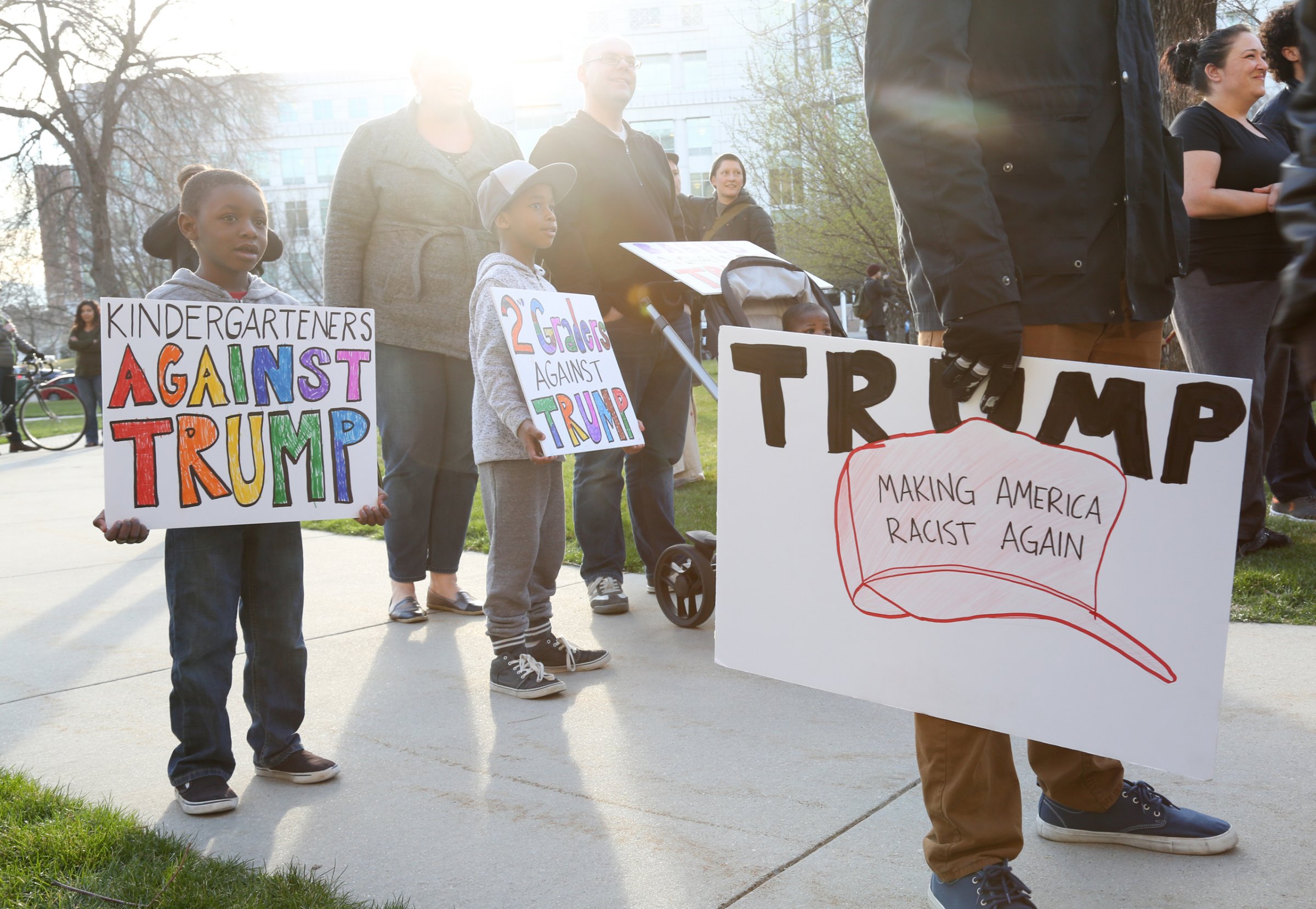 Brothers Noah, left and Owen Burket hold signs as they protest with their family at a rally outside the Infinity Events Center in Salt Lake City, where Republican Presidential candidate Donald Trump held a campaign rally on March 18, 2016.