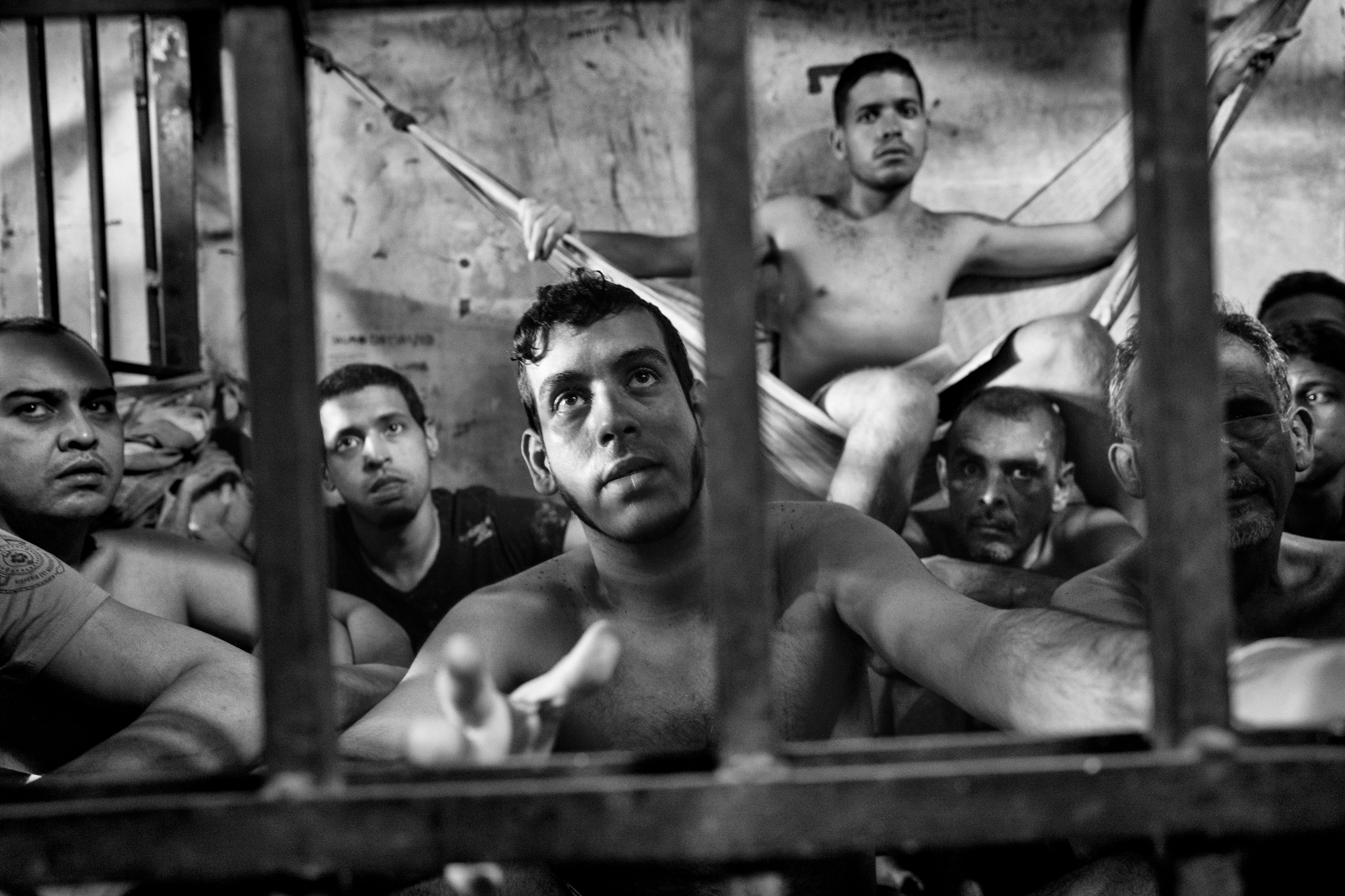 Prisoners inside a crowded cell at the Chacao municipal police station in eastern Caracas. There is no room to  sit and prisoners take turns resting on sheets tied to bars like hammocks.  Jails in Venezuela are seriously overcrowded with shortages of food and medicine. Because of the economic and political crisis, the number of prisoners grows daily as more Venezuelans are arrested for crimes, including mugging, kidnapping and murder, June 2016.