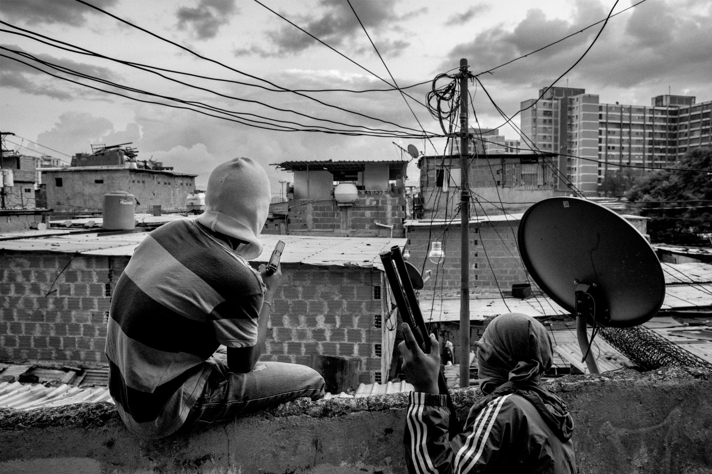 Members of a criminal gang lookout over their neighborhood in Caracas, Venezuela. Their faces are covered to avoid being identified by police, Caracas, Venezuela, Sept. 2015