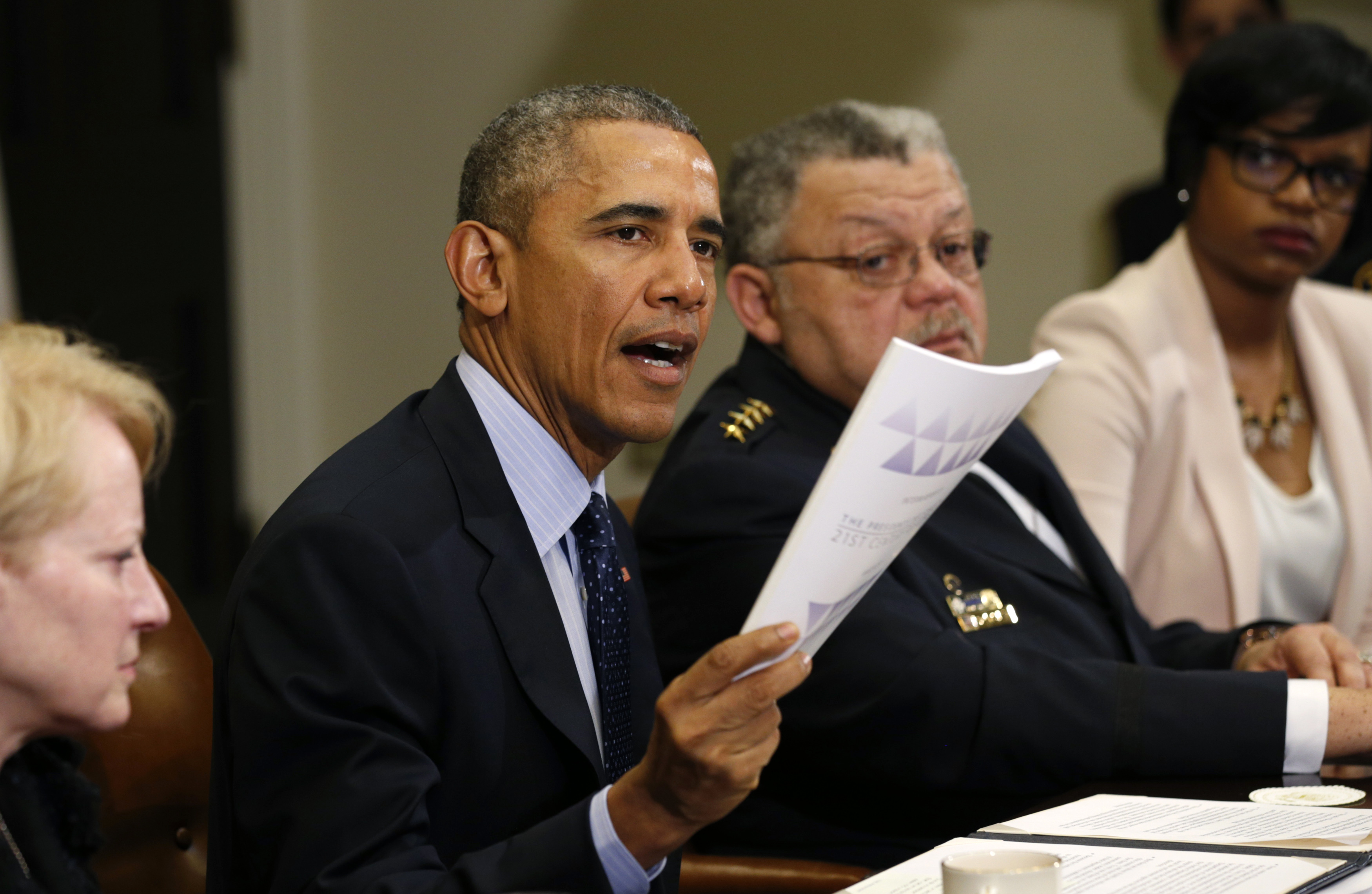 President Barack Obama holds up a copy of the report by the Task Force on 21st Century Policing at the White House in Washington, March 2, 2015. (Kevin Lamarque—Reuters)