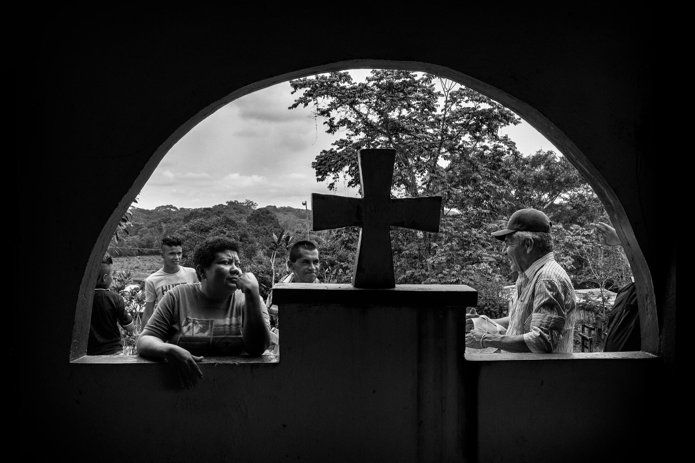 A group of civilians wait for a mass in the village of Puerto Camelias, Caqueta, Colombia, which is one of the villages under FARC guerrilla control, Caqueta region, March, 2016.