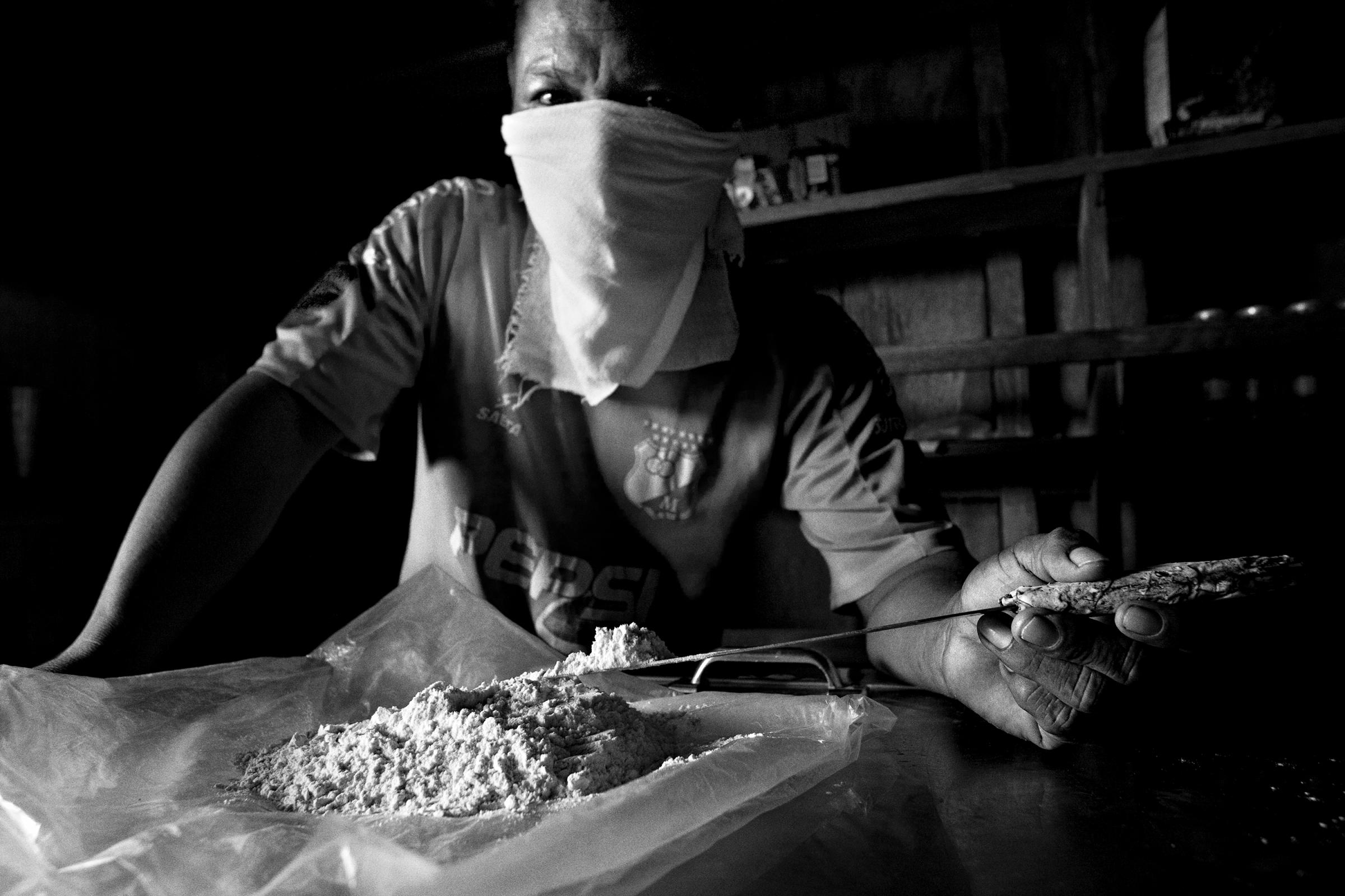 A local narcotics dealer holds up pure cocaine. All the different armed groups who take part in the conflict benefit from this market, with cocoa cultivation being the main source of income for families in this region, Colombia, Nov. 2007.