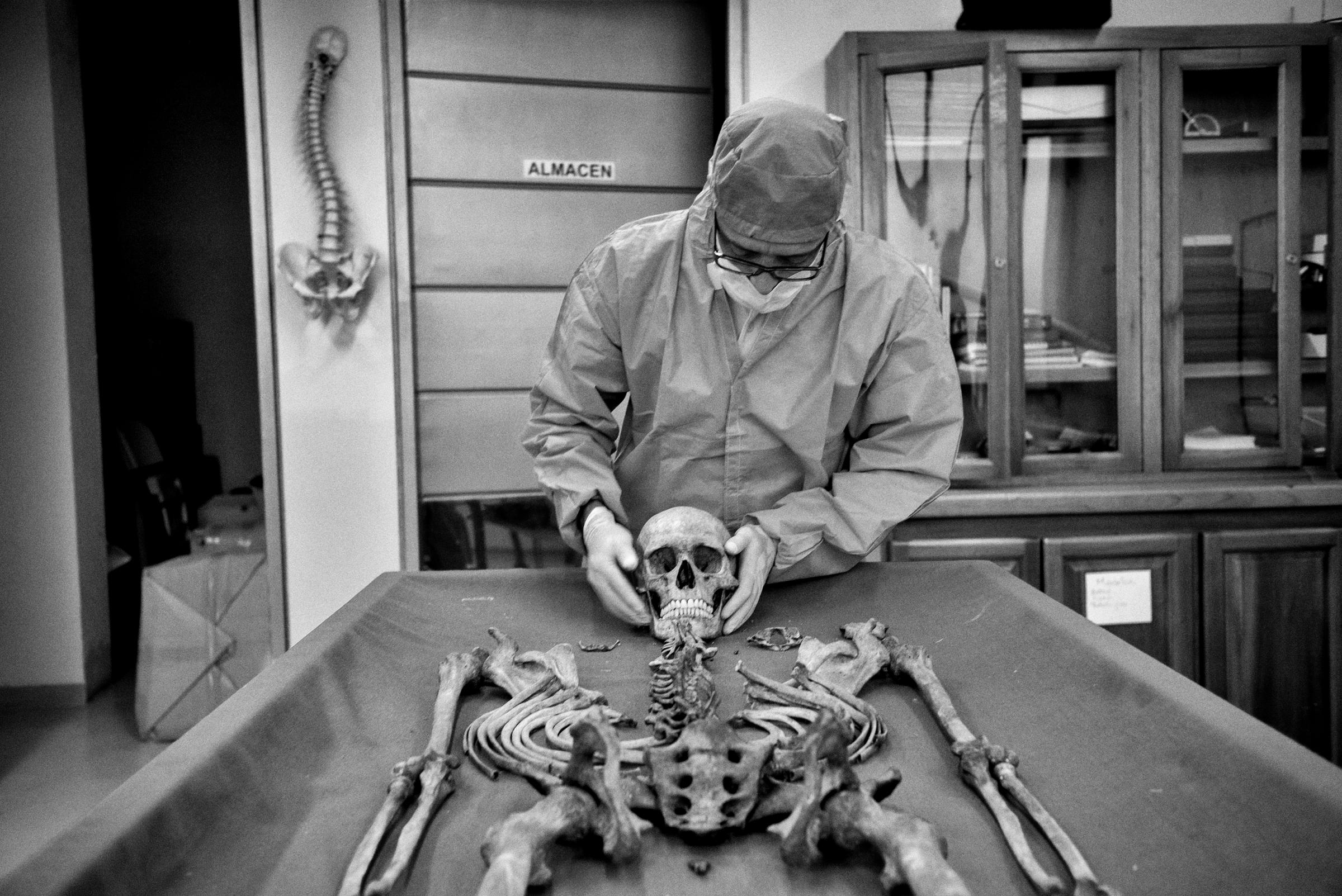 A Forensic investigator with the Colombian Prosecutor's office examines an unidentified corpse (NN). The Human identification group from Antioquia, Colombia is comprised of four anthropologists, three dentists, two doctors, one assistant and a photographer. Since it was established, they have done 1325 exhumations of unidentified corpses, of which 653 have been identified and returned to their families. There are more than 96,000 people missing in Colombia, Antioquia, Medellin,March 2015.