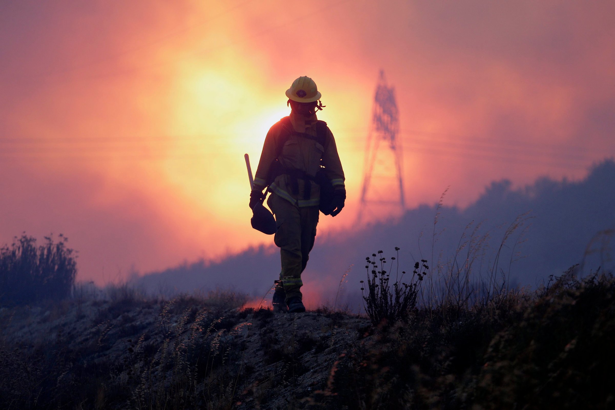 A firefighter keeps an eye on the Blue Cut fire line, north of Los Angeles, Calif, Aug. 16, 2016.