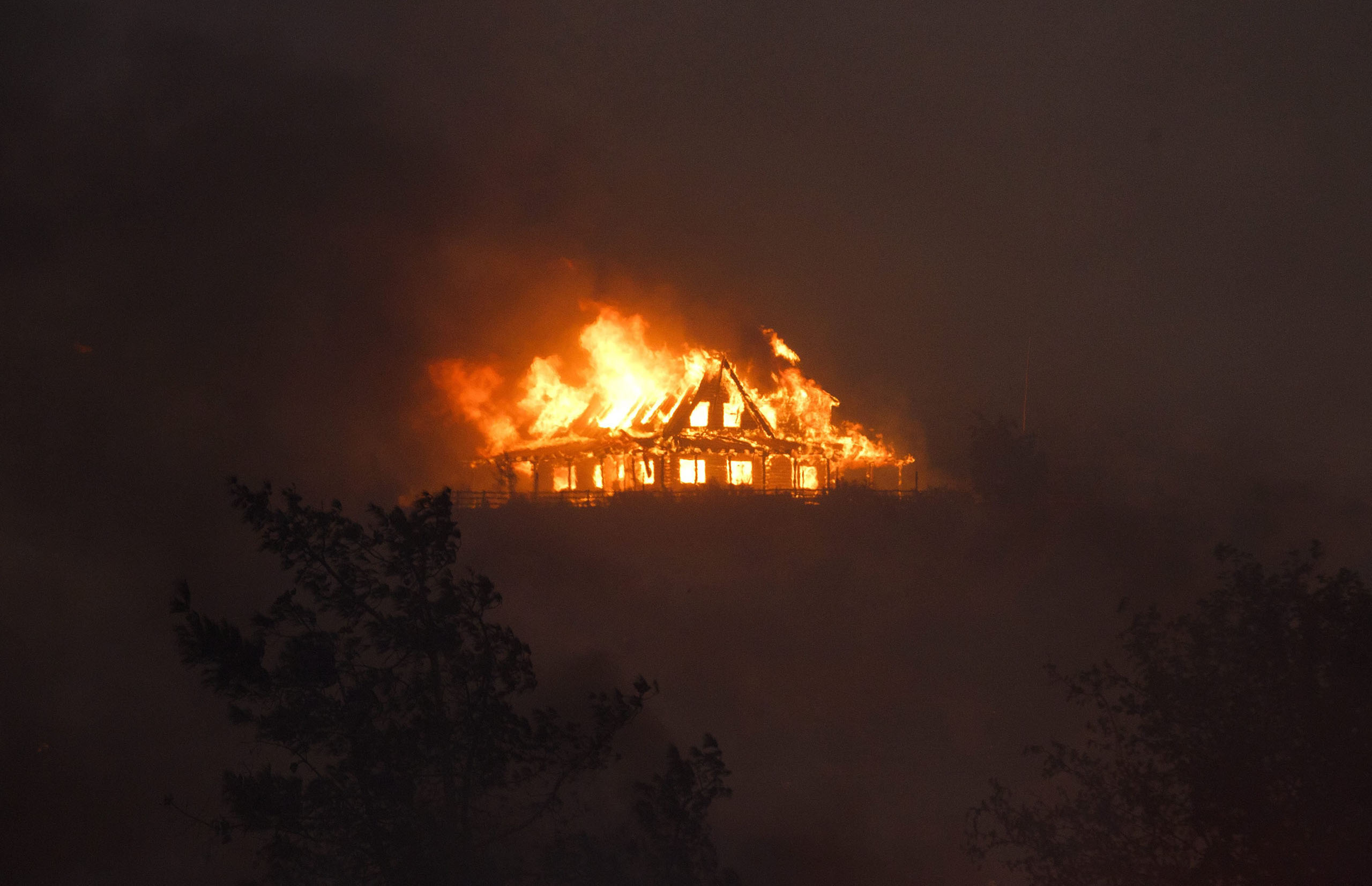 A house burns on a hill near Cajon Junction, Calif., Aug. 16, 2016.