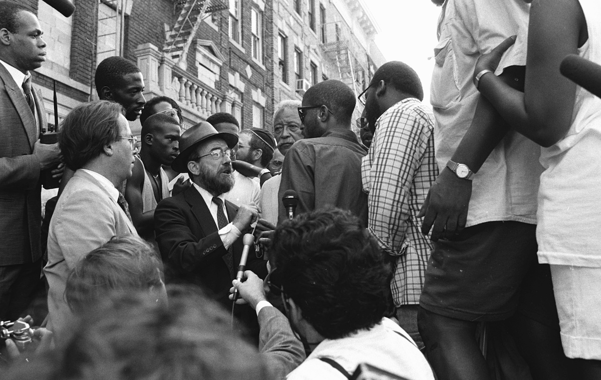 Mayor David Dinkins looks on while a Hasidic Jew and a black man argue during riots in Crown Heights in 1991. (New York Daily News Archive / Getty Images)