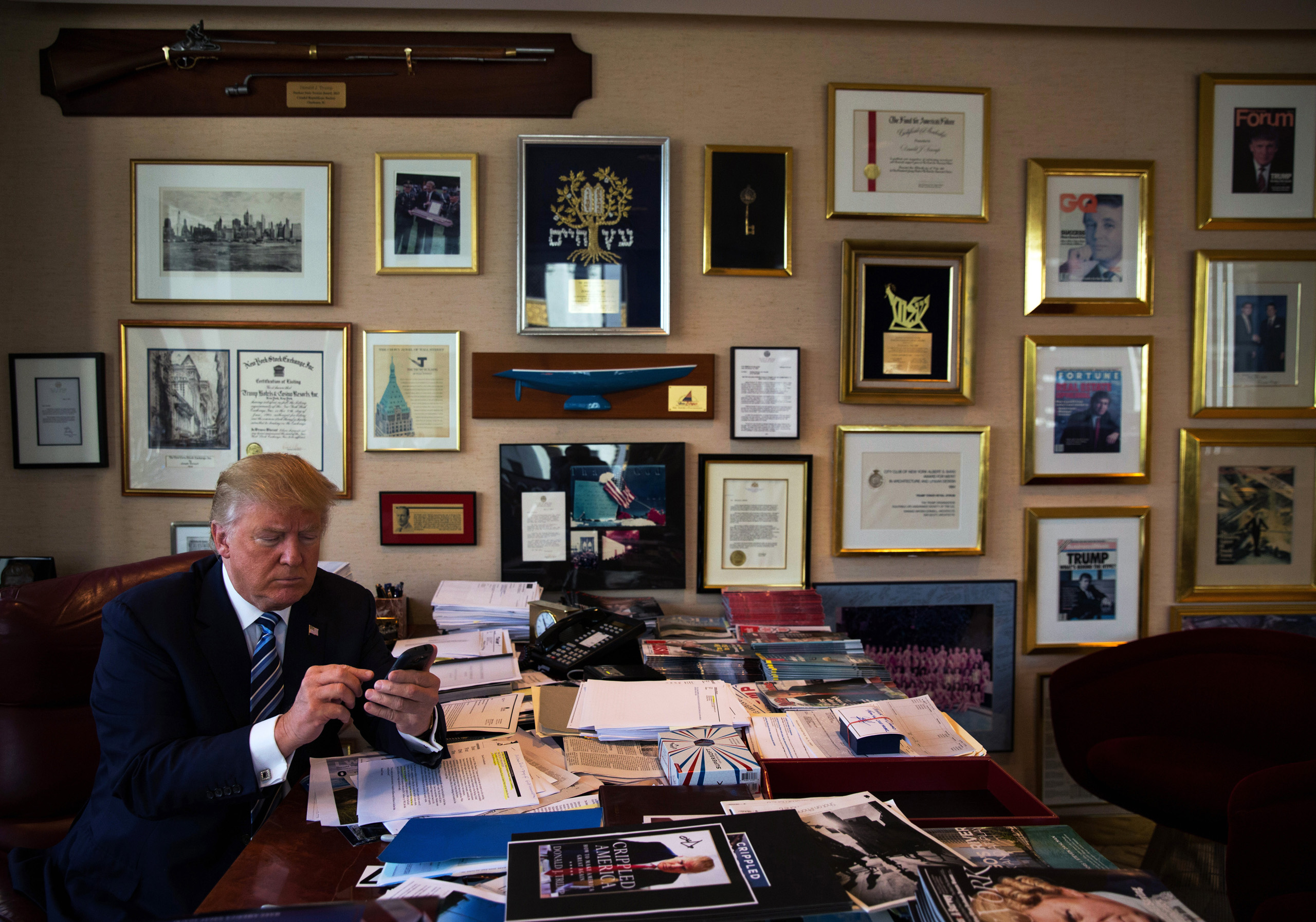 Donald Trump demonstrates how he Tweets using his Samsung phone in his office in the Trump Tower in New York.