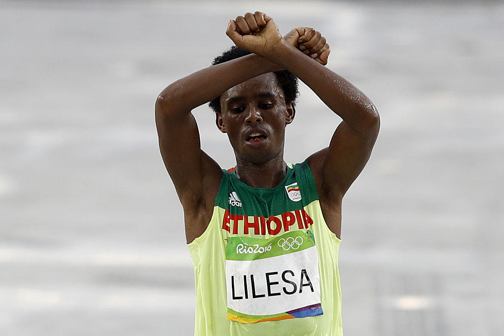 Ethiopia's Feyisa Lilesa (silver) crosses the finish line of the Men's Marathon athletics event during the Rio 2016 Olympic Games at the Sambodromo in Rio de Janeiro on August 21, 2016.  
                      Lilesa crossed his arms above his head as he finished the race as a protest against the Ethiopian government's crackdown on political dissent. (ADRIAN DENNIS&mdash;AFP/Getty Images)