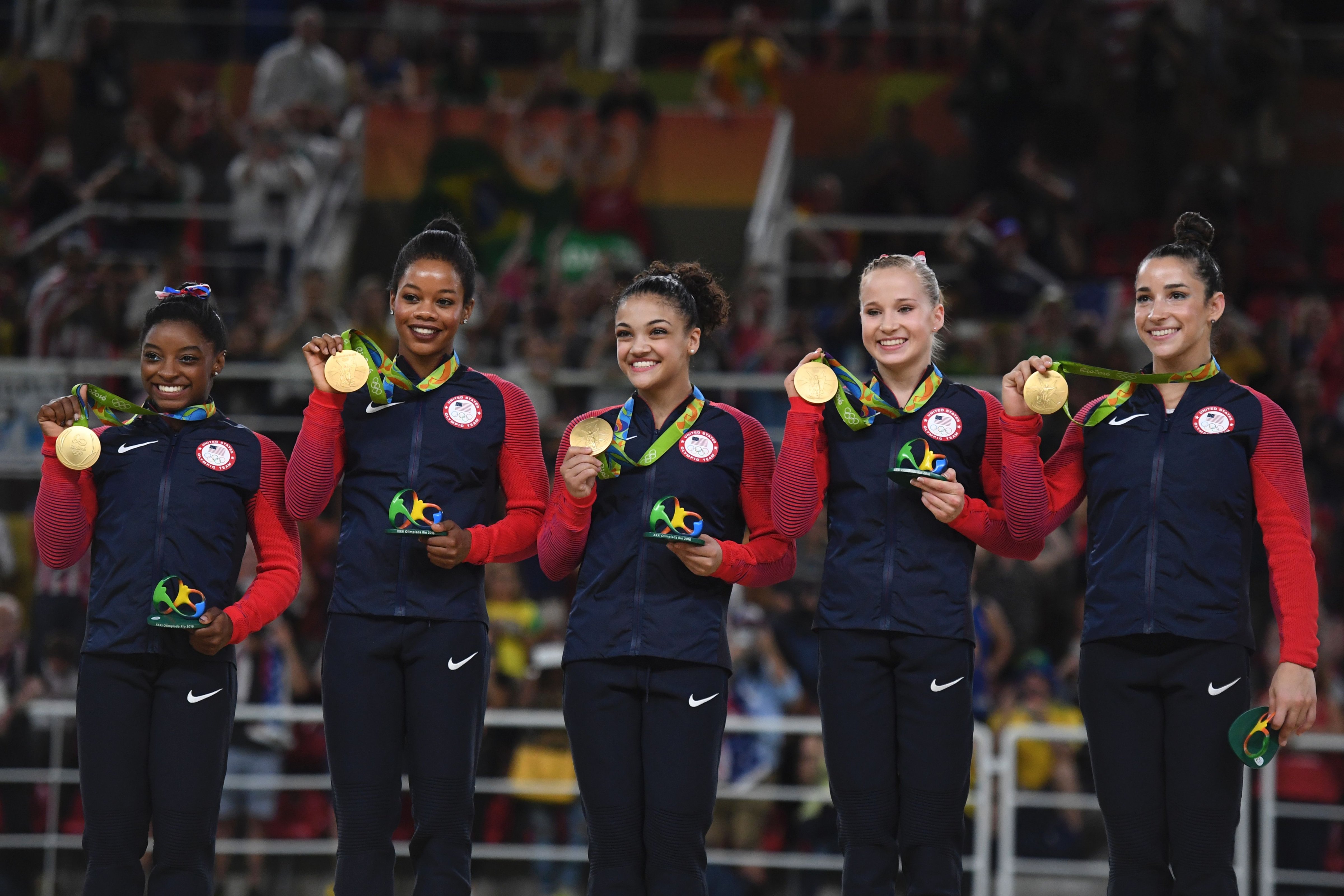 (R-L) US gymnasts Alexandra Raisman, Madison Kocian, Lauren Hernandez, Gabrielle Douglas and Simone Biles celebrate with their gold medals on the podium during the women's team final Artistic Gymnastics at the Olympic Arena during the Rio 2016 Olympic Games in Rio de Janeiro on August 9, 2016. / AFP / Ben STANSALL        (Photo credit should read BEN STANSALL/AFP/Getty Images) (Ben Stansall&mdash;Getty Images)