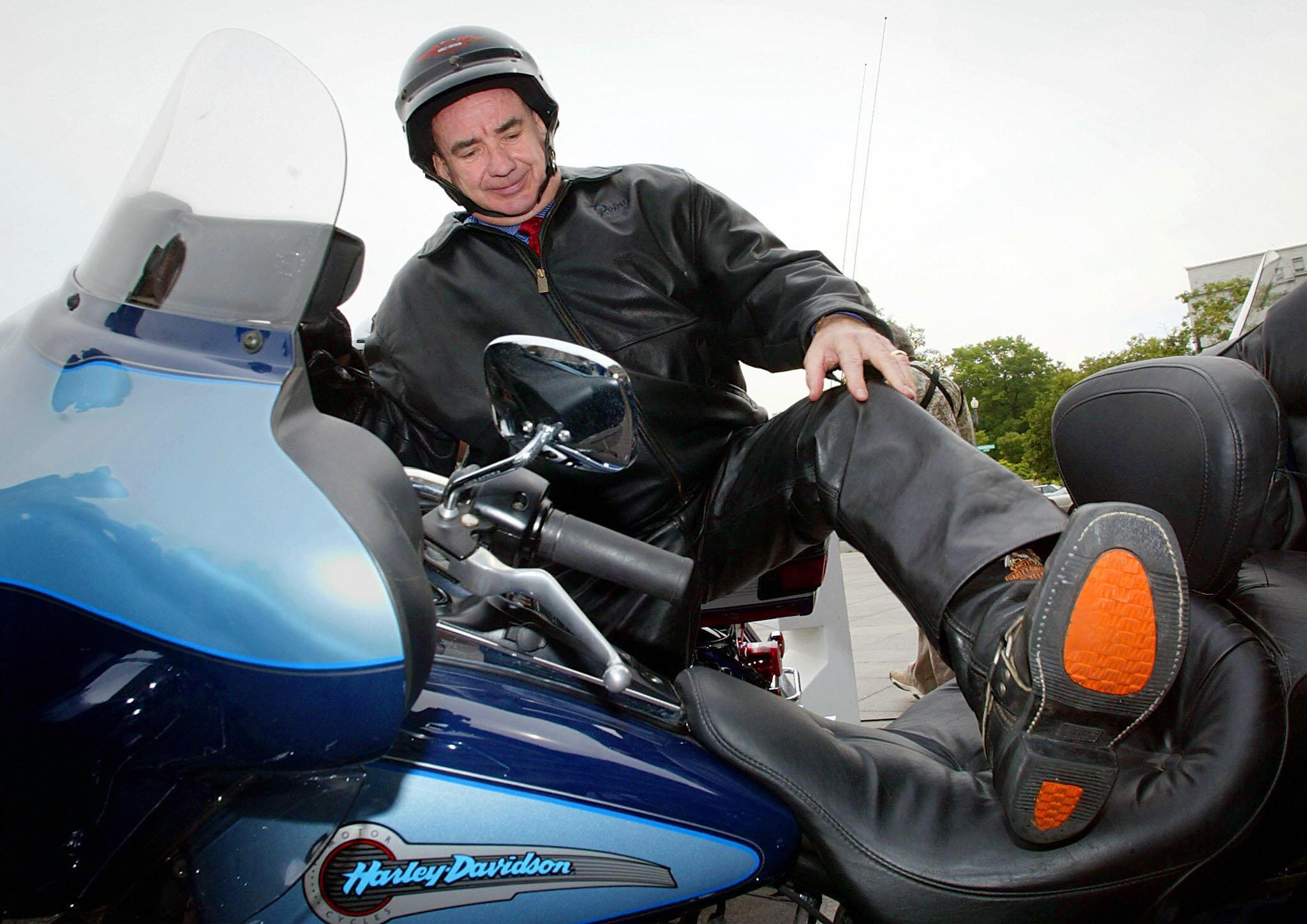 Health and Human Services (HHS) Secretary Tommy Thompson gets on a Harley Davidson motorcycle clad in his leather pants for a ride outside HHS headquarters 16 June 2003 in Washington, DC.