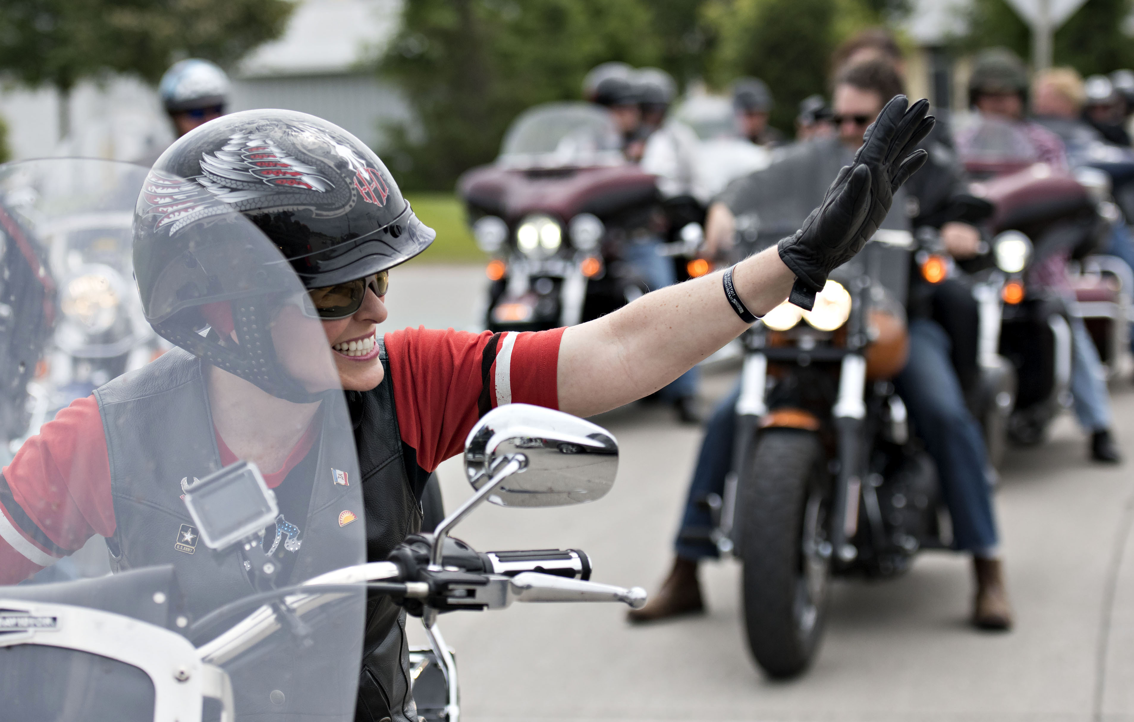 Senator Joni Ernst, a Republican from Iowa, waves to supporters as she rides the lead bike in a group motorcycle ride in Des Moines, Iowa, U.S., on Saturday, June 6, 2015.